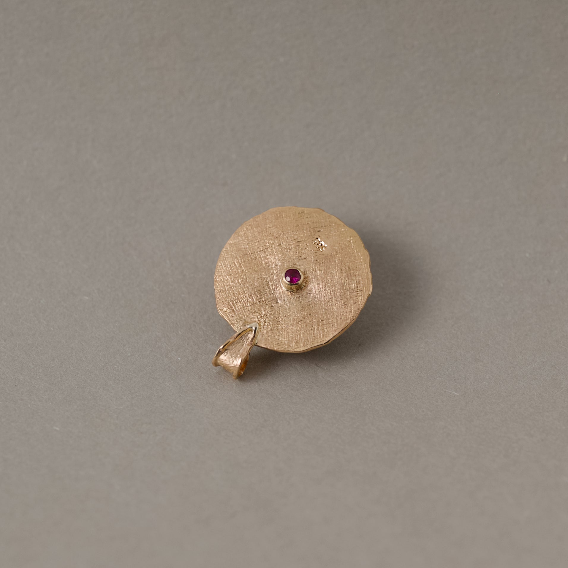 14ct gold medallion with ruby gemstones and white moonstone showing back with ruby gemstone accent