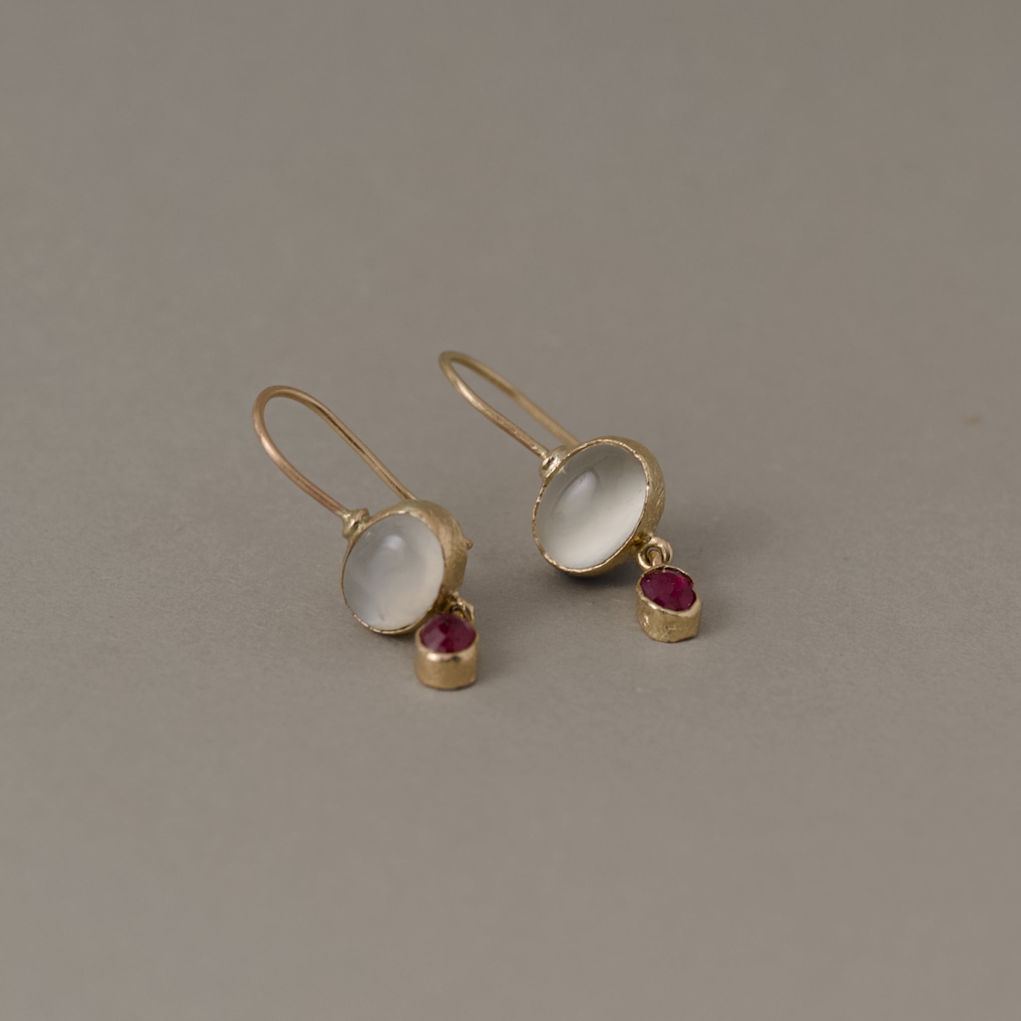 Sera gold earrings featuring moonstone and ruby gemstones
