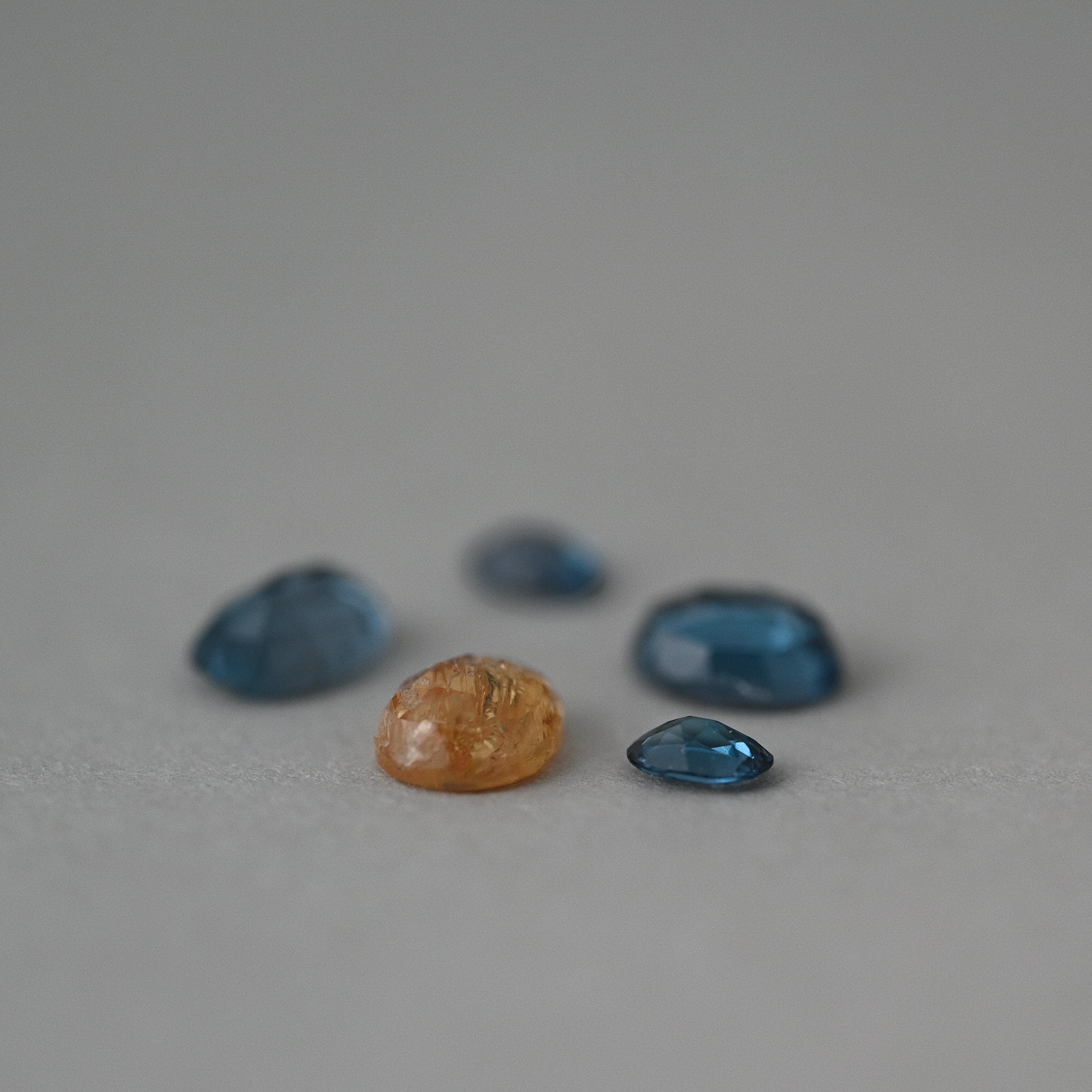 loose mixed topaz gemstones on grey paper
