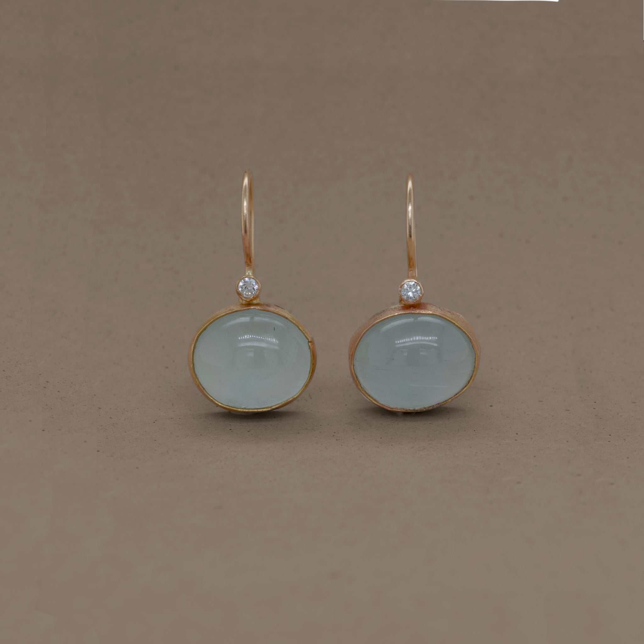 Handcrafted gold earrings with milky aquamarine stones and diamonds.