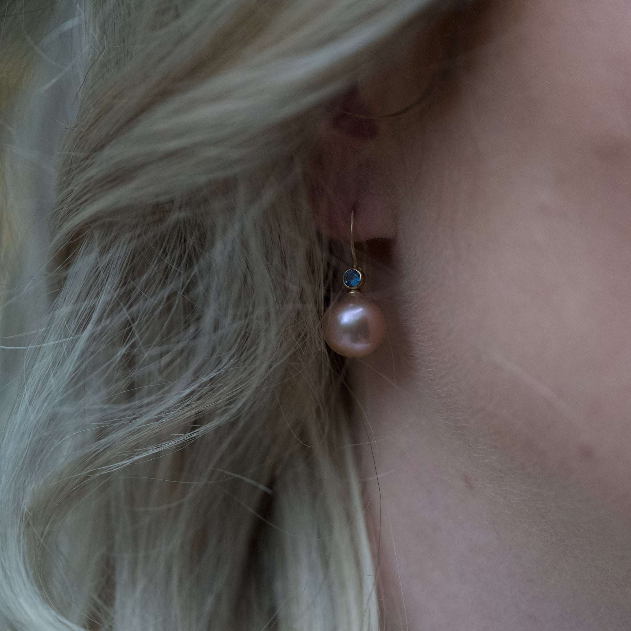 Latte Rose freshwater pearl and blue sapphire gold earrings shown worn with close-up on ear and blonde hair
