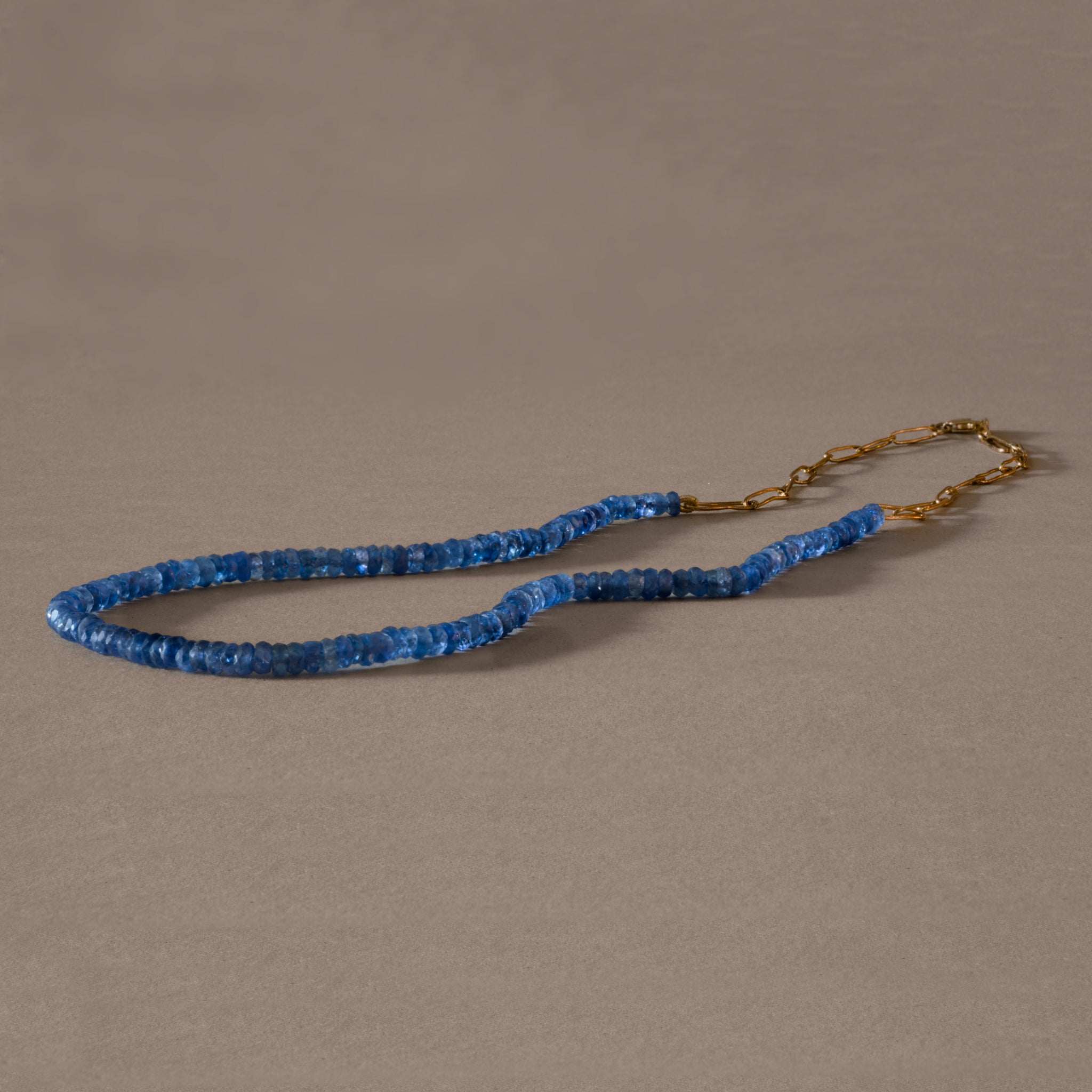 Elegant blue sapphire necklace with delicate gold links, symbolizing sincerity and devotion