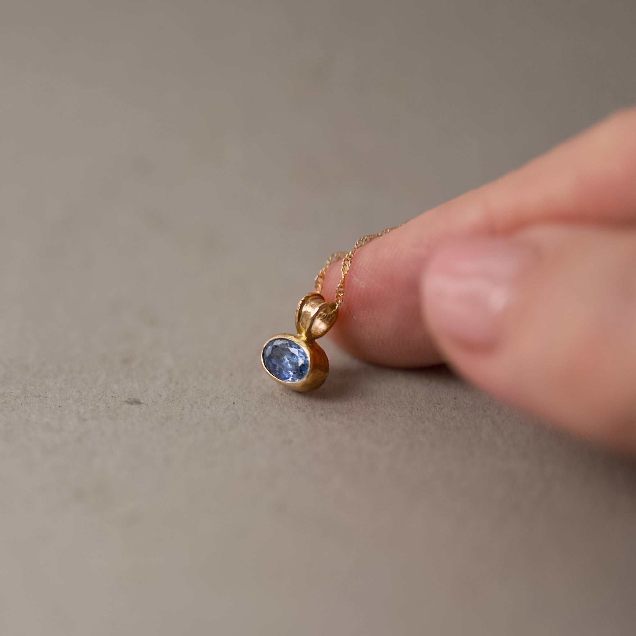 Ceylon blue sapphire pendant set in gold with radiant cornflower blue sapphire centerpiece