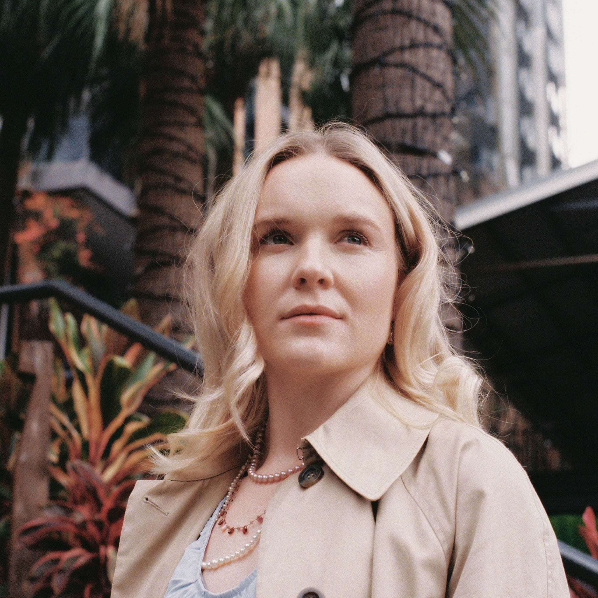 Woman wearing Ondina Freshwater Pearl Necklace outdoors with palm trees in the background