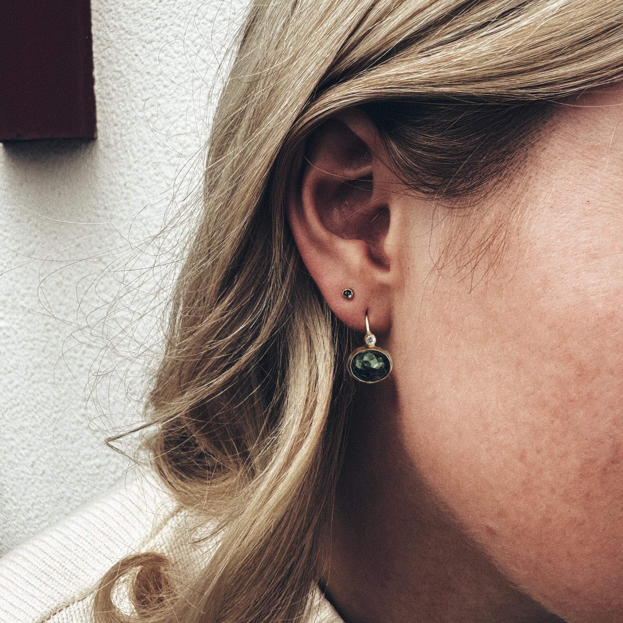 Earrings featuring green Paraiba tourmaline and diamonds in 14ct gold.