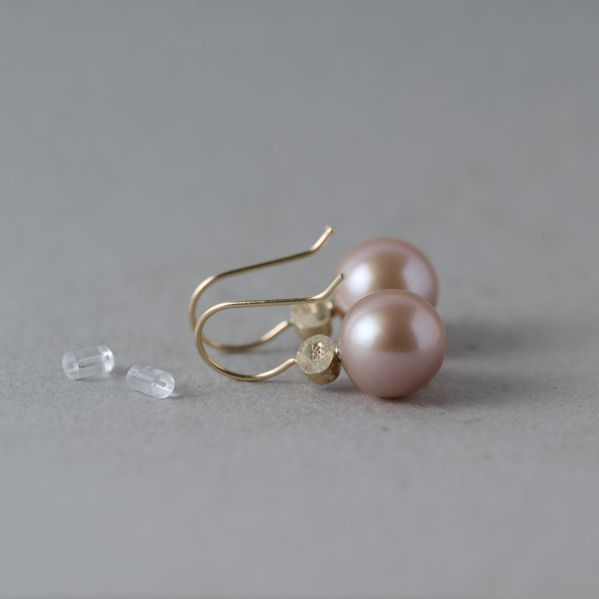 backs of pink sapphire and Edison pearl earrings in 14ct gold with hallmark