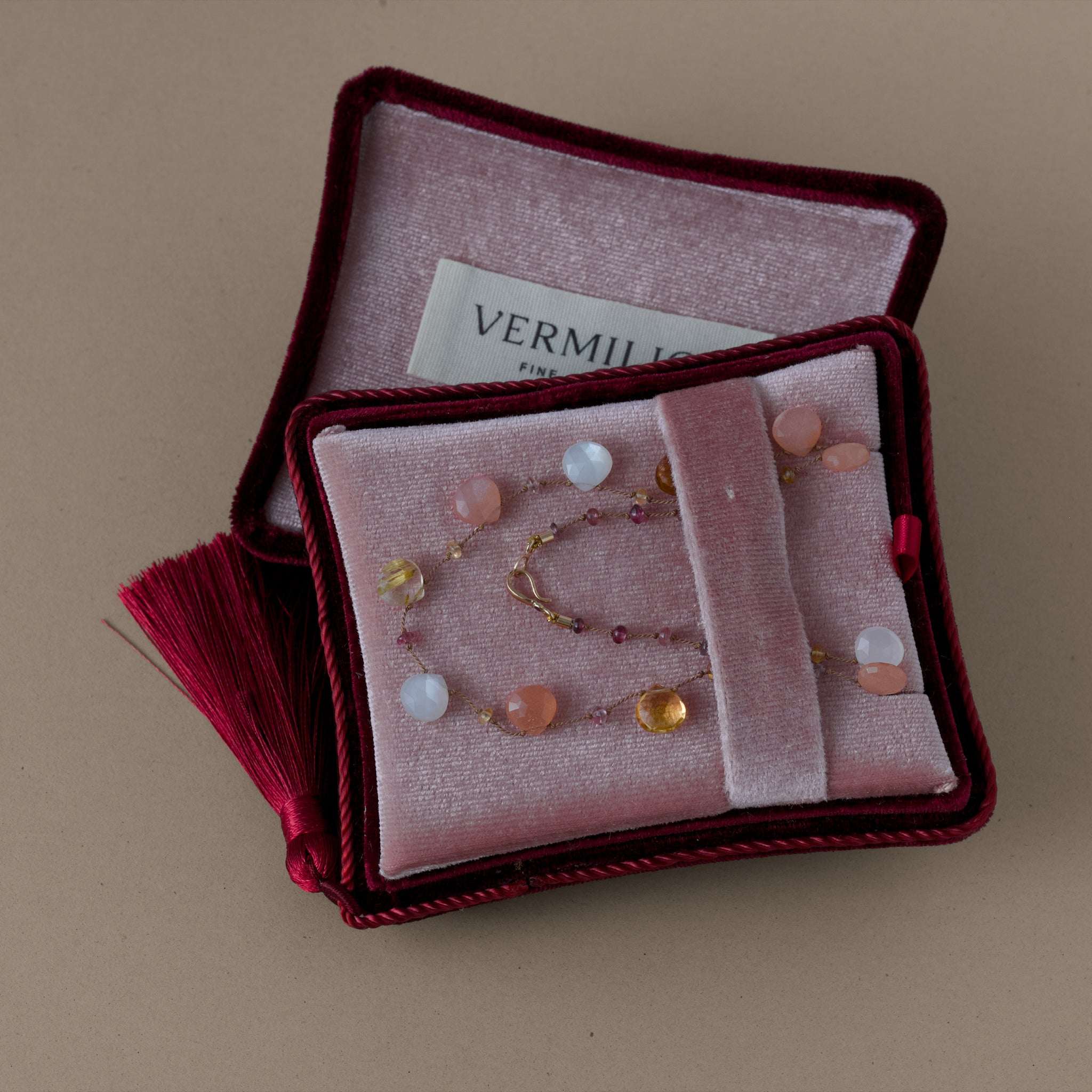 Moonstone citrine gemstone necklace with gold clasp and ruby adornment in a velvet box.