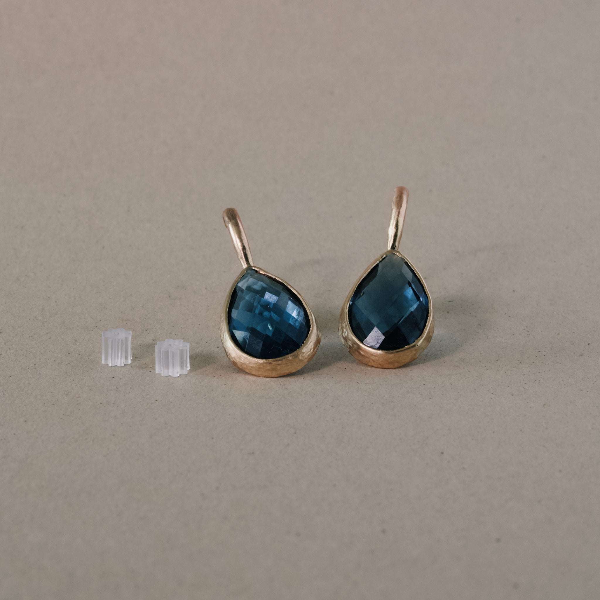 Elegant blue topaz earrings with unique cut and gold setting.