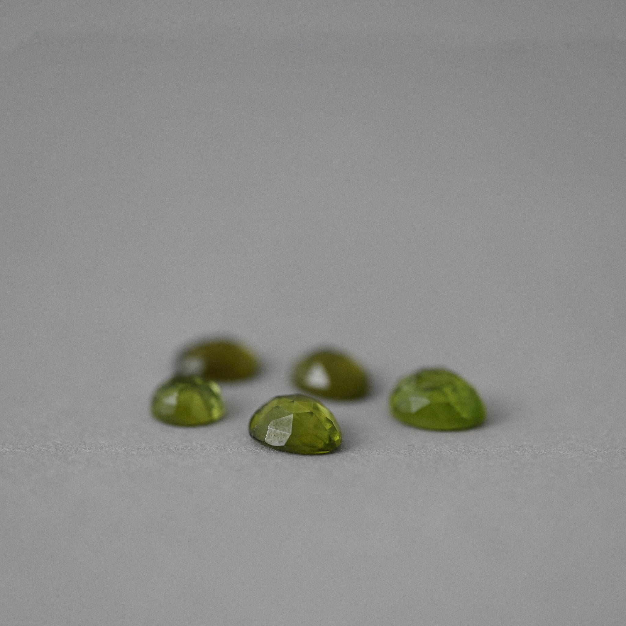 loose Arizona peridot on grey paper