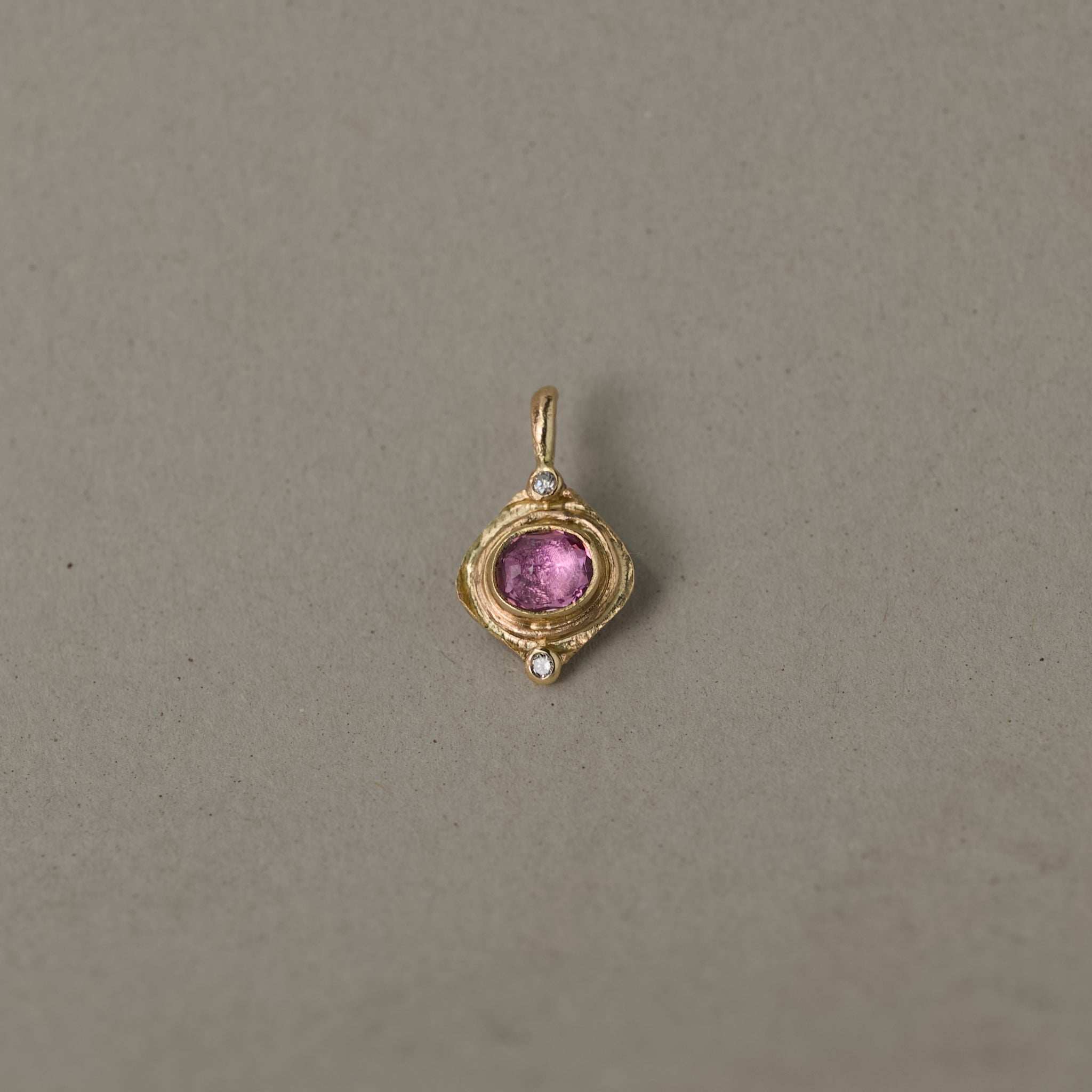 Handcrafted gold pendant featuring pink sapphire and diamonds, elegant jewelry design