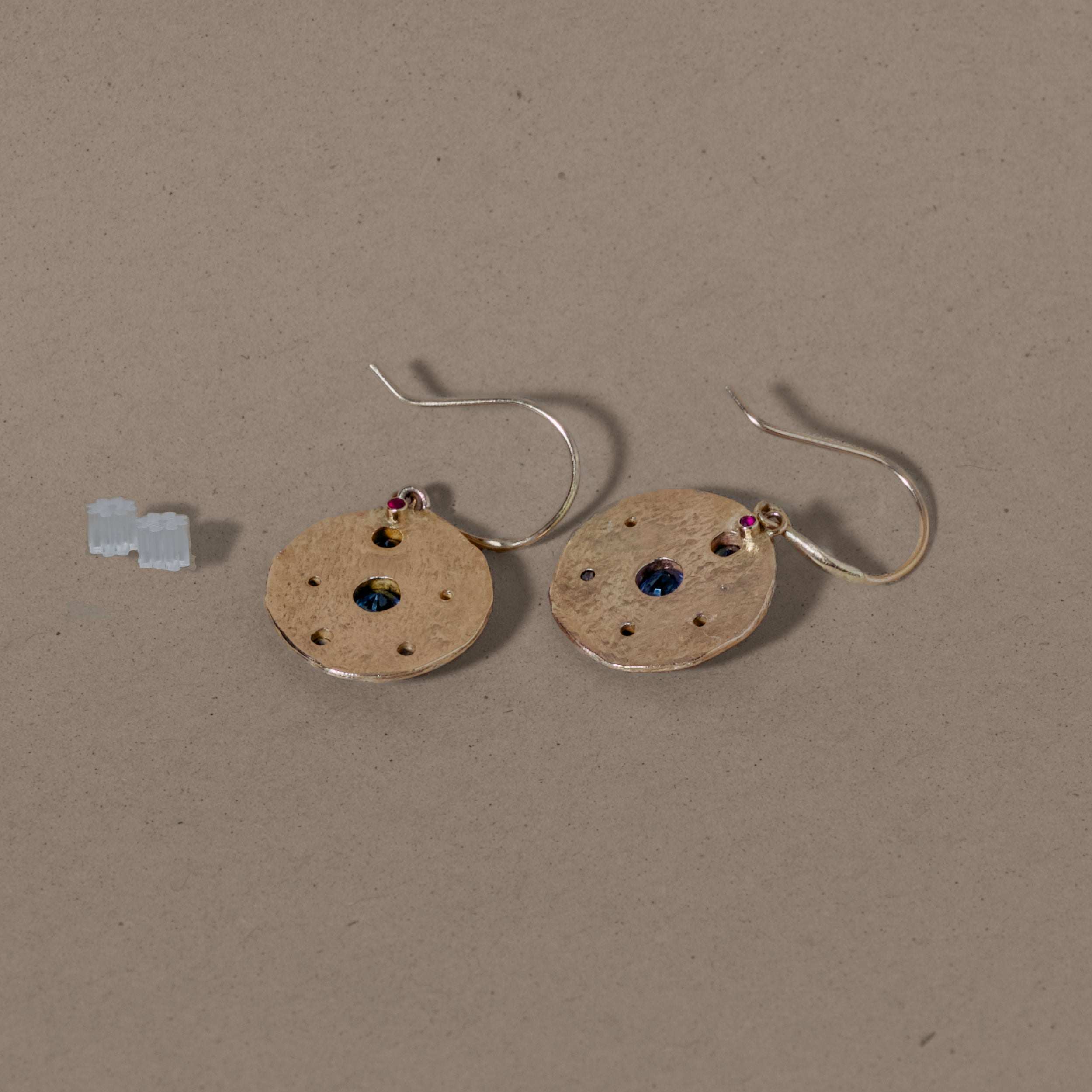 Florin sapphire diamond earrings with 14ct gold and mixed Ceylon and Arizona sapphires on a beige background