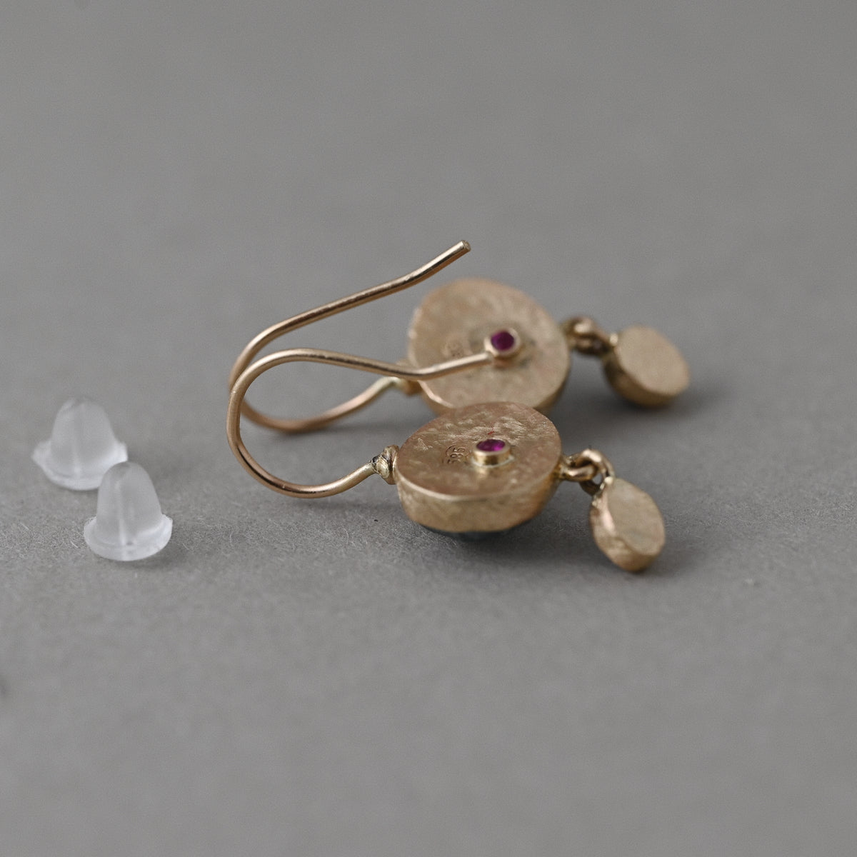 Sera moss aquamarine and Ceylon sapphire earrings in 14ct solid gold, showing signature ruby details on the reverse and silicone stoppers