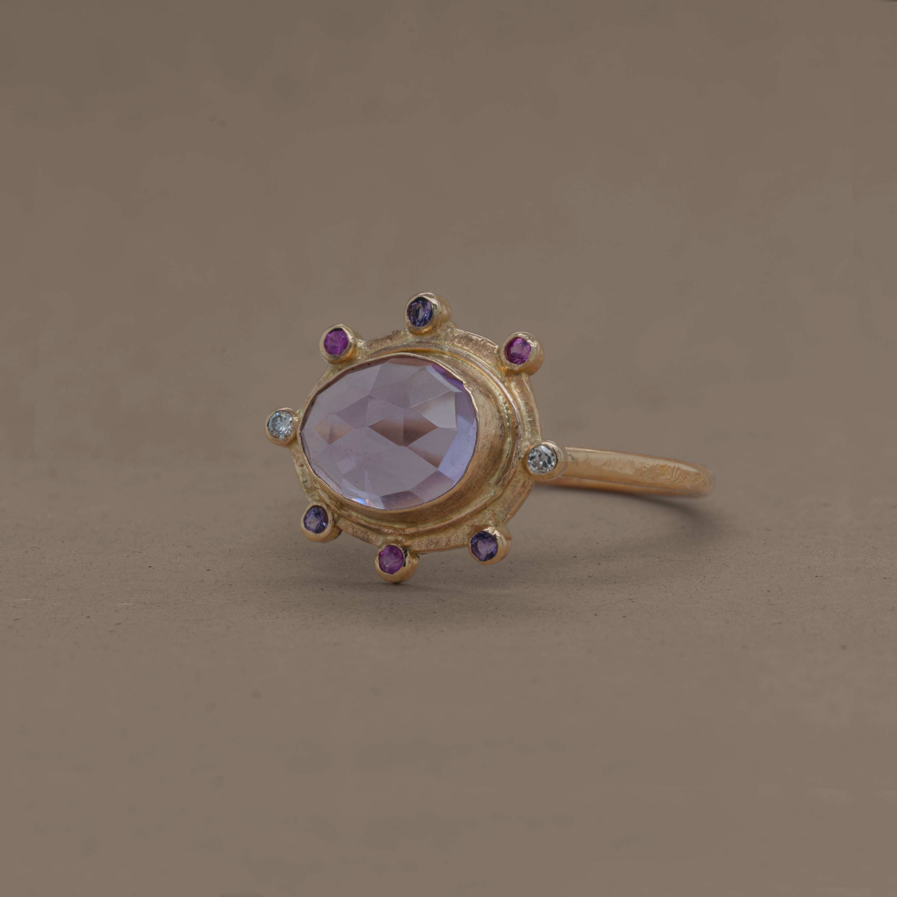 Amethyst ring with gold band, adorned with sapphires and diamonds.