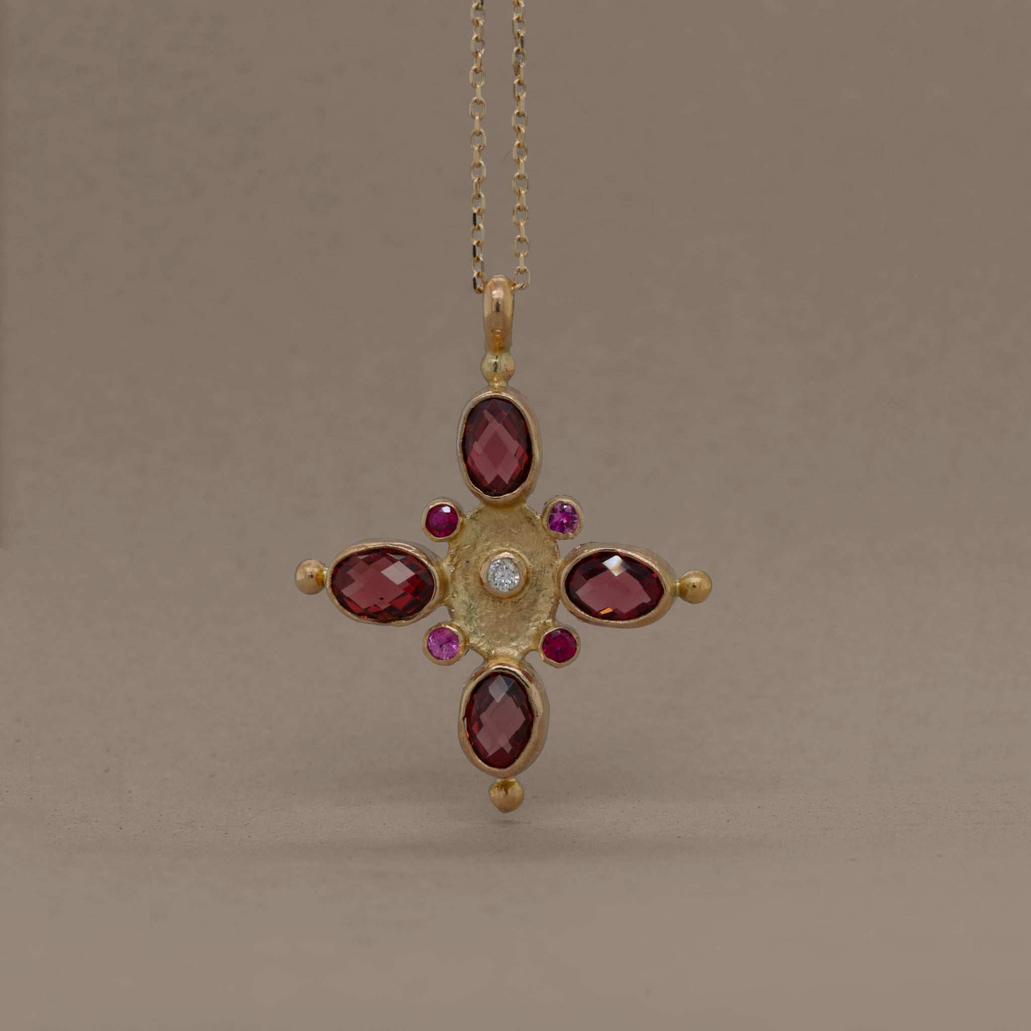 Garnet and sapphire necklace with gold, ruby, and diamond accents.