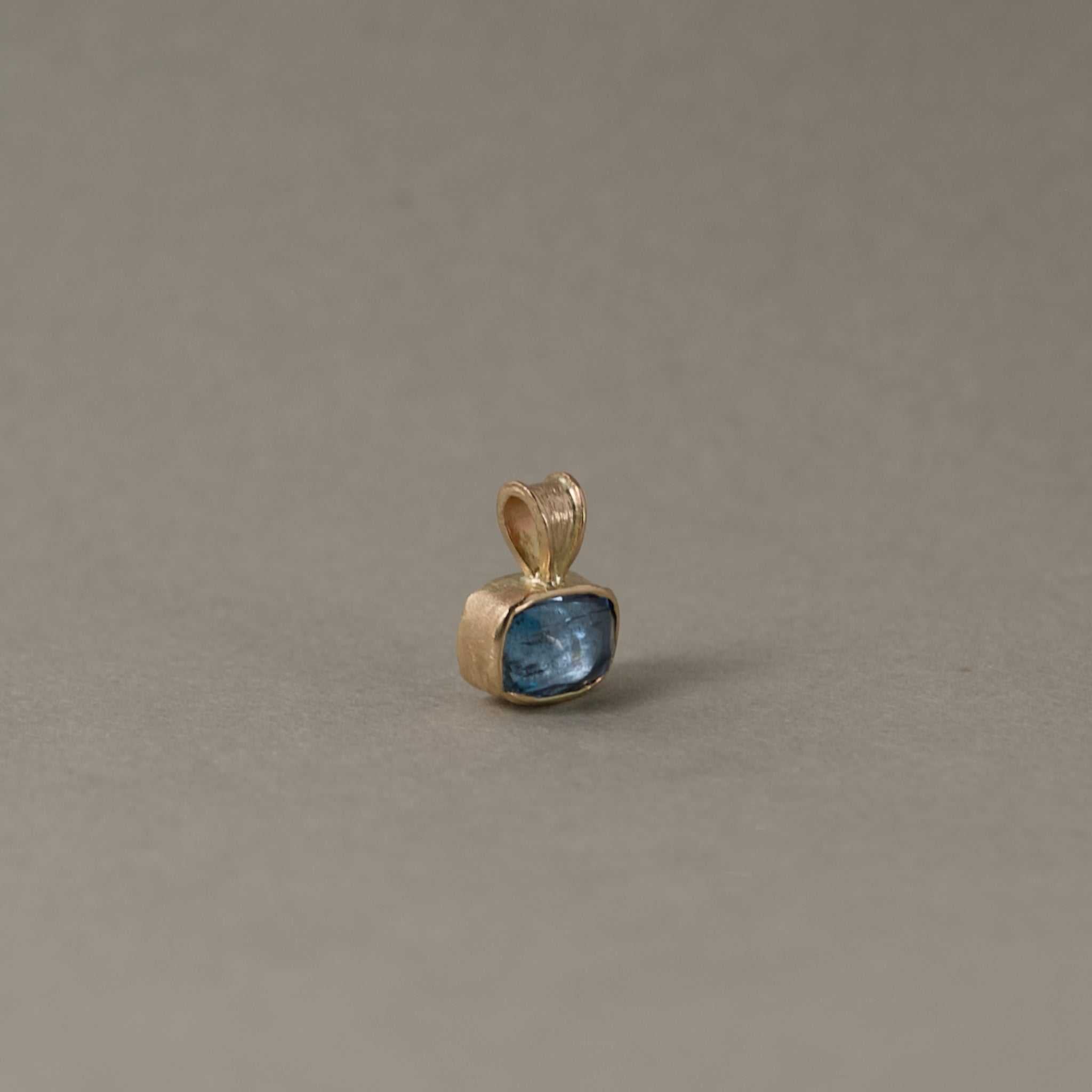 Uno Aquamarine Pendant necklace with a blue aquamarine gemstone set in gold, symbolizing serenity and calm.