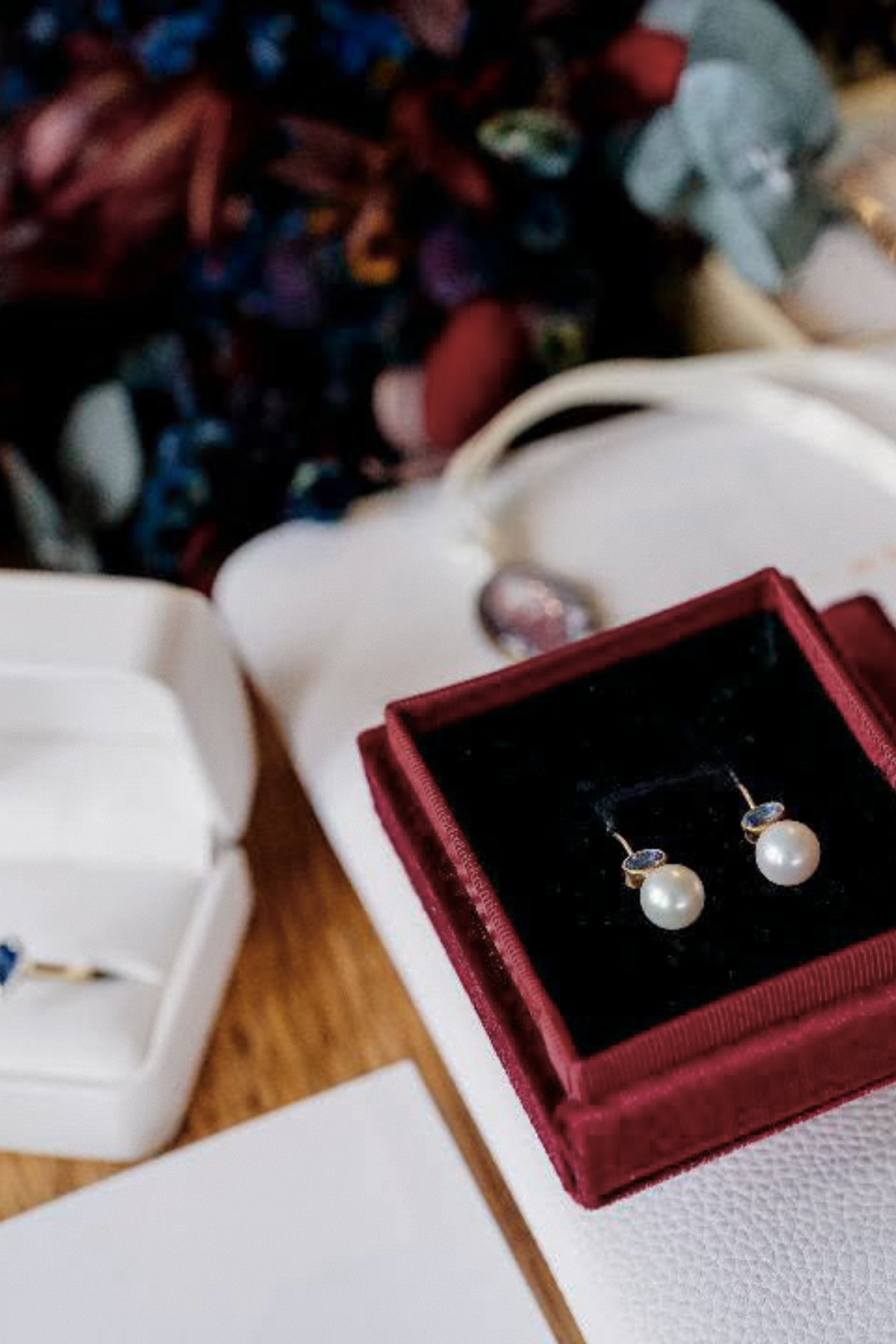 Ceylon blue sapphire and freshwater pearl earrings displayed in a vermilion jewellery box before the wedding ceremony