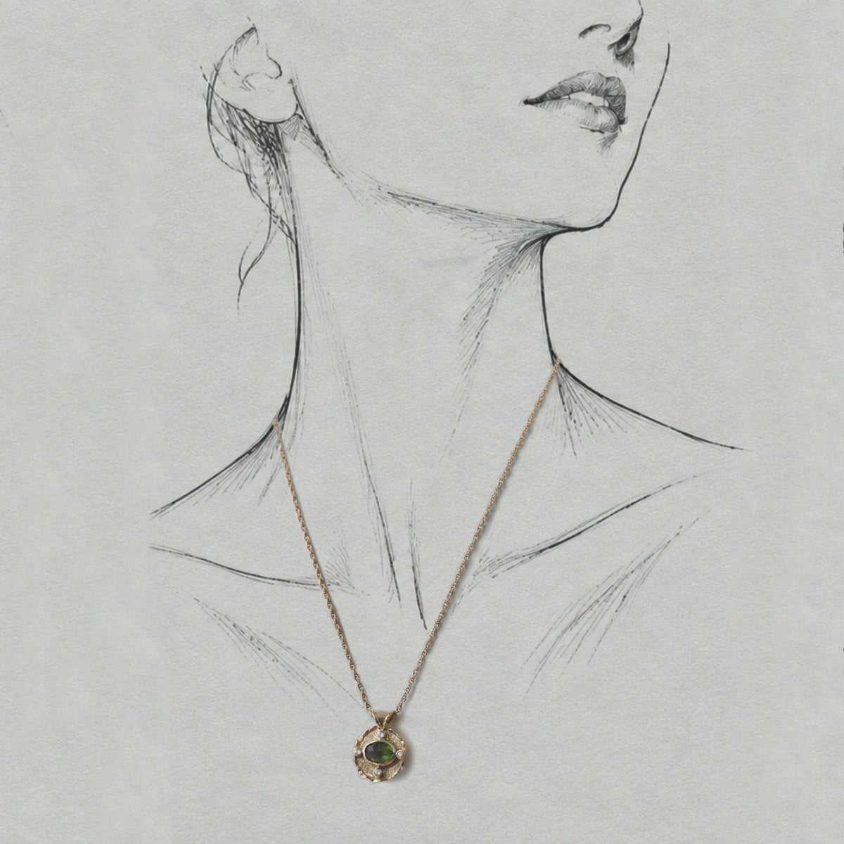 Vermilion Jewellery Uno green tourmaline pendant in 14ct solid gold, shown on an artist model wearing a fine gold chain.