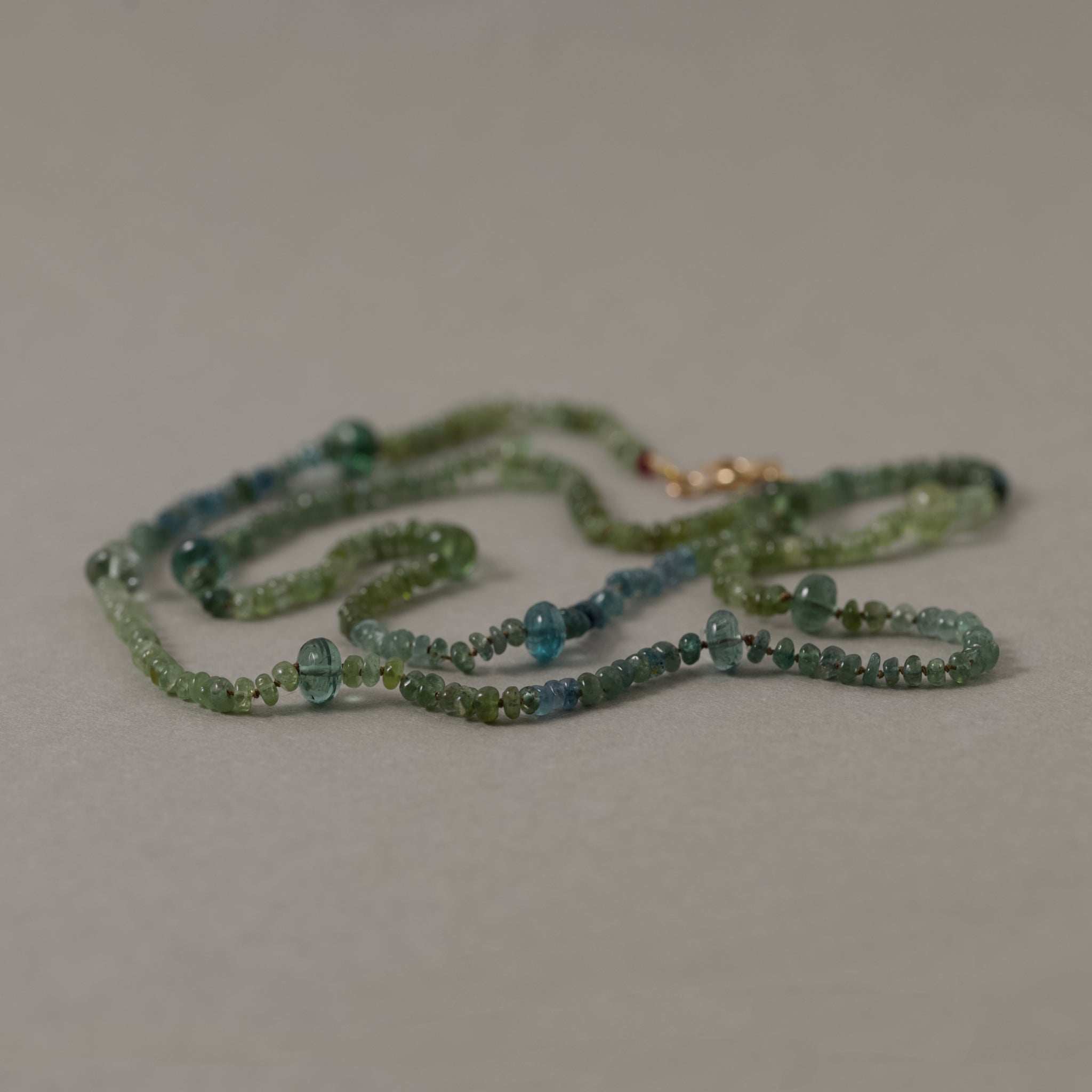 Filo Green Tourmaline Necklace with blue-green tourmalines in silk strand and gold accents