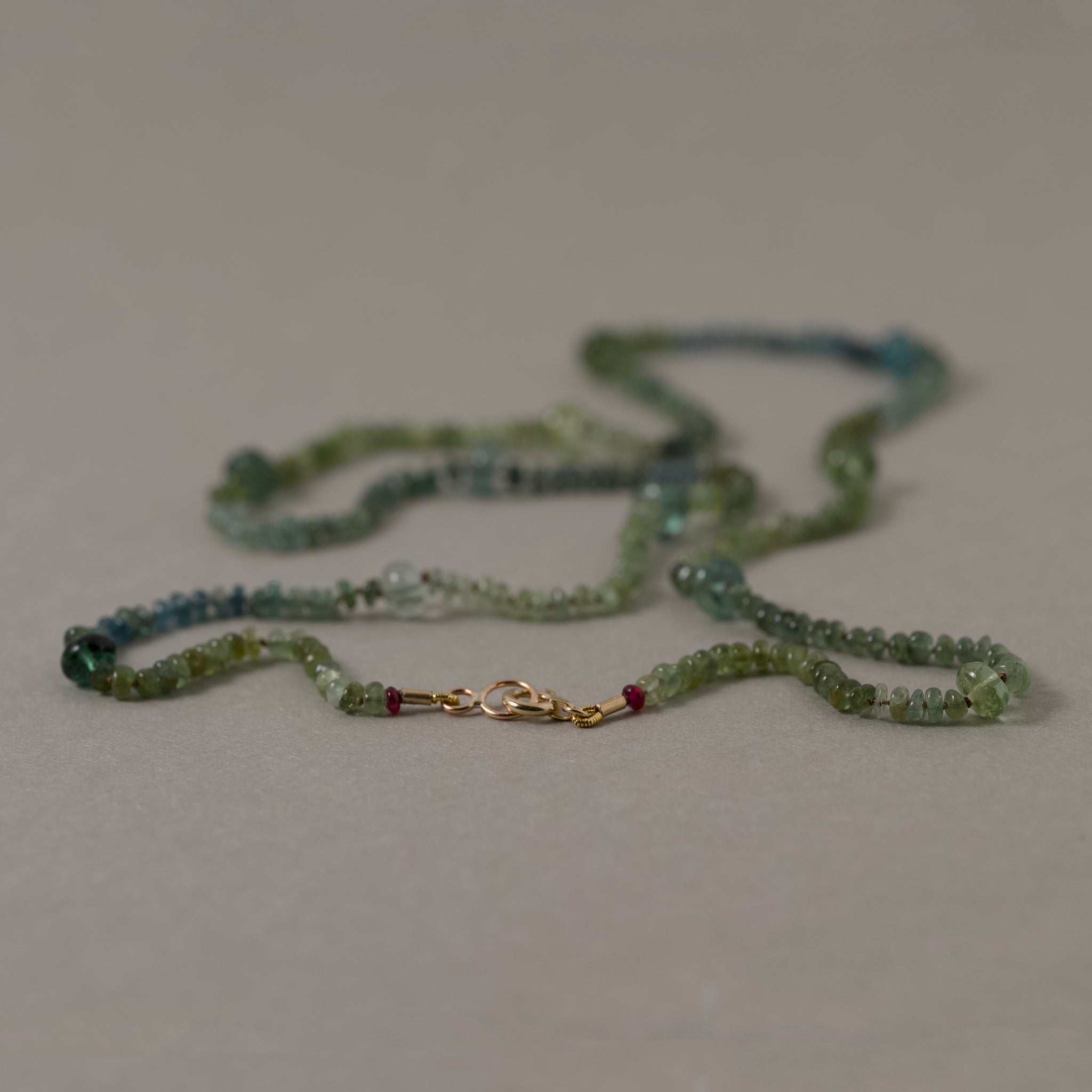 Filo Green Tourmaline Necklace with gold and silk strand showcasing blue to green tourmalines