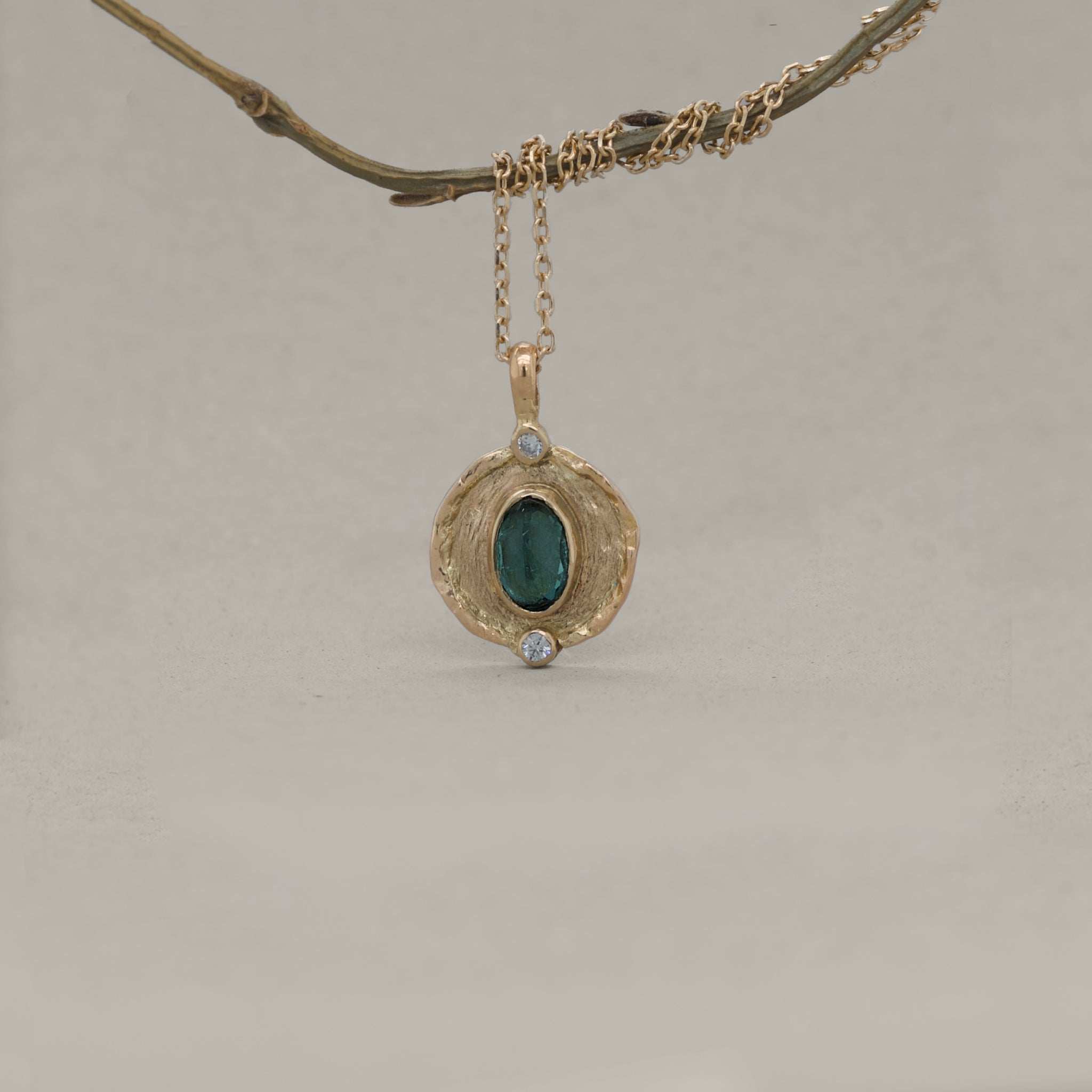 Florin Indicolite Tourmaline necklace with brushed gold medallion and diamond accents hanging from delicate gold chain