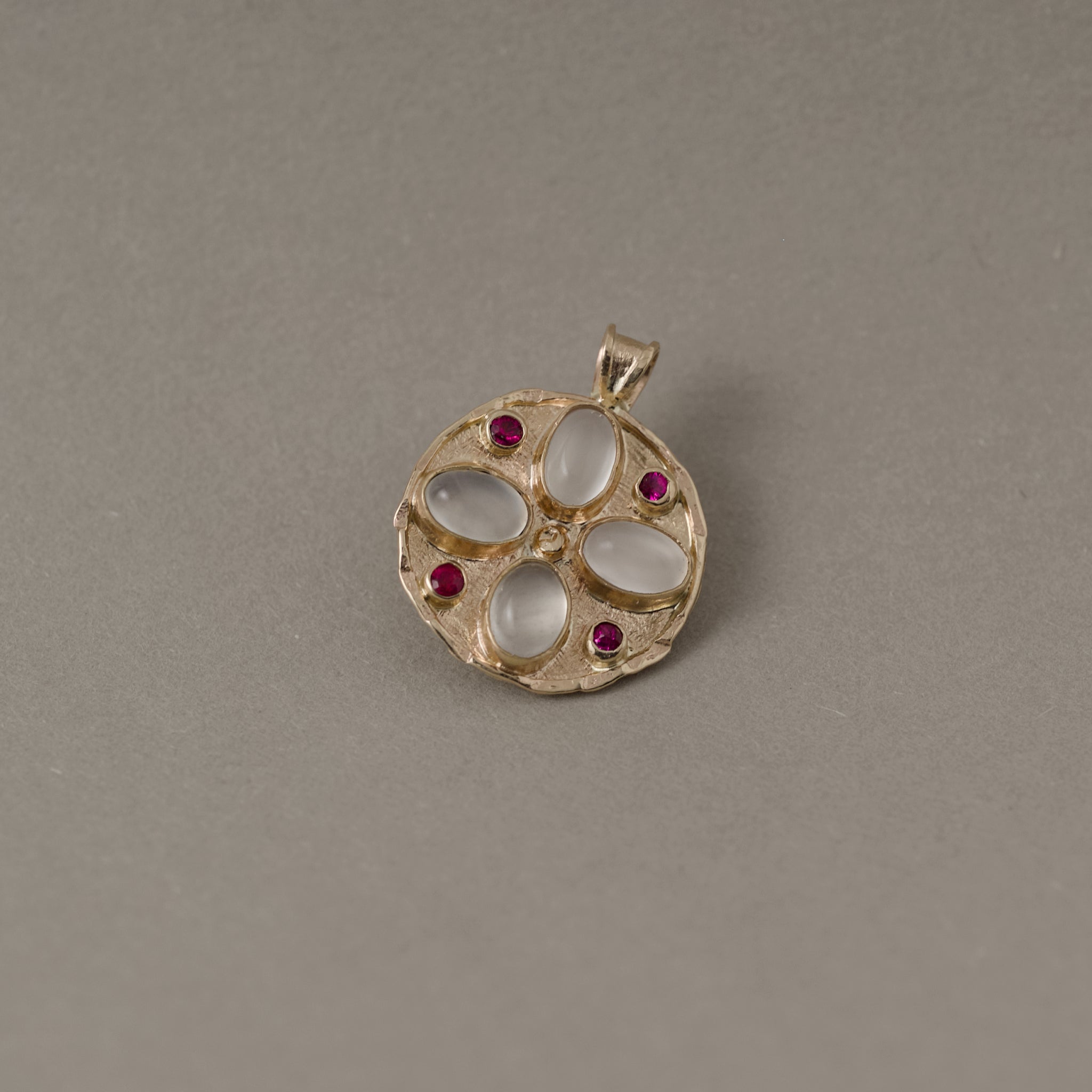 14ct gold medallion with ruby gemstones and white moonstone