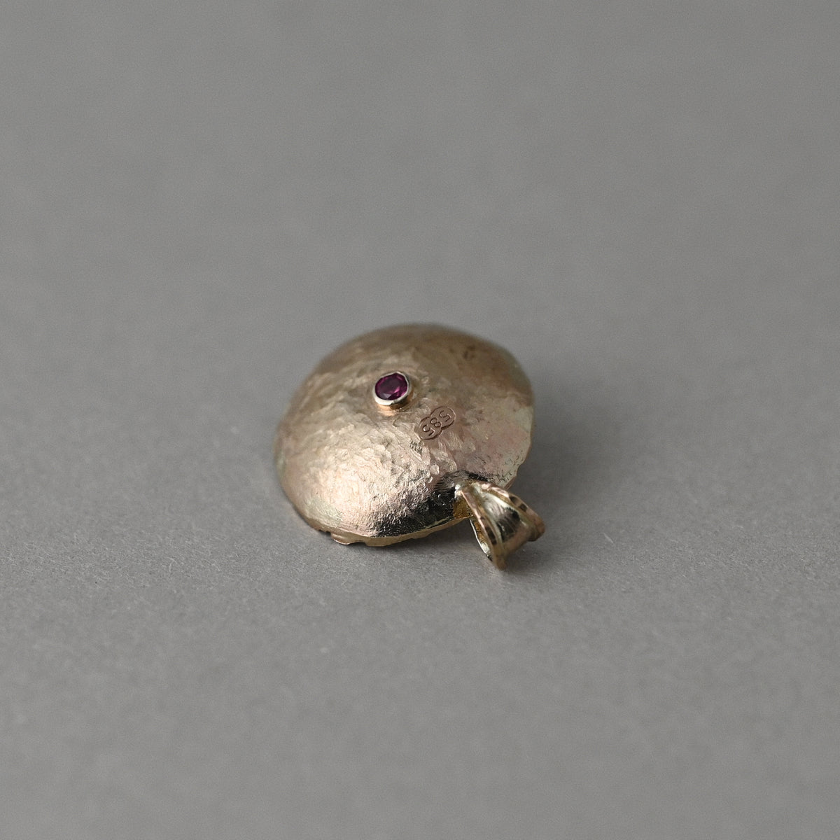 Domed back of 14ct gold Florin sapphire pendant with ruby signature and 585 hallmark