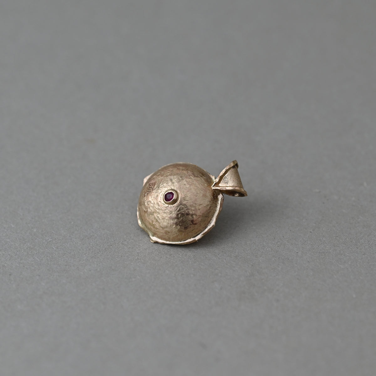 Vermilion Jewellery Florin  tourmaline medallion in 14ct solid gold, showing back of its curve with a ruby gemstone and hallmark.