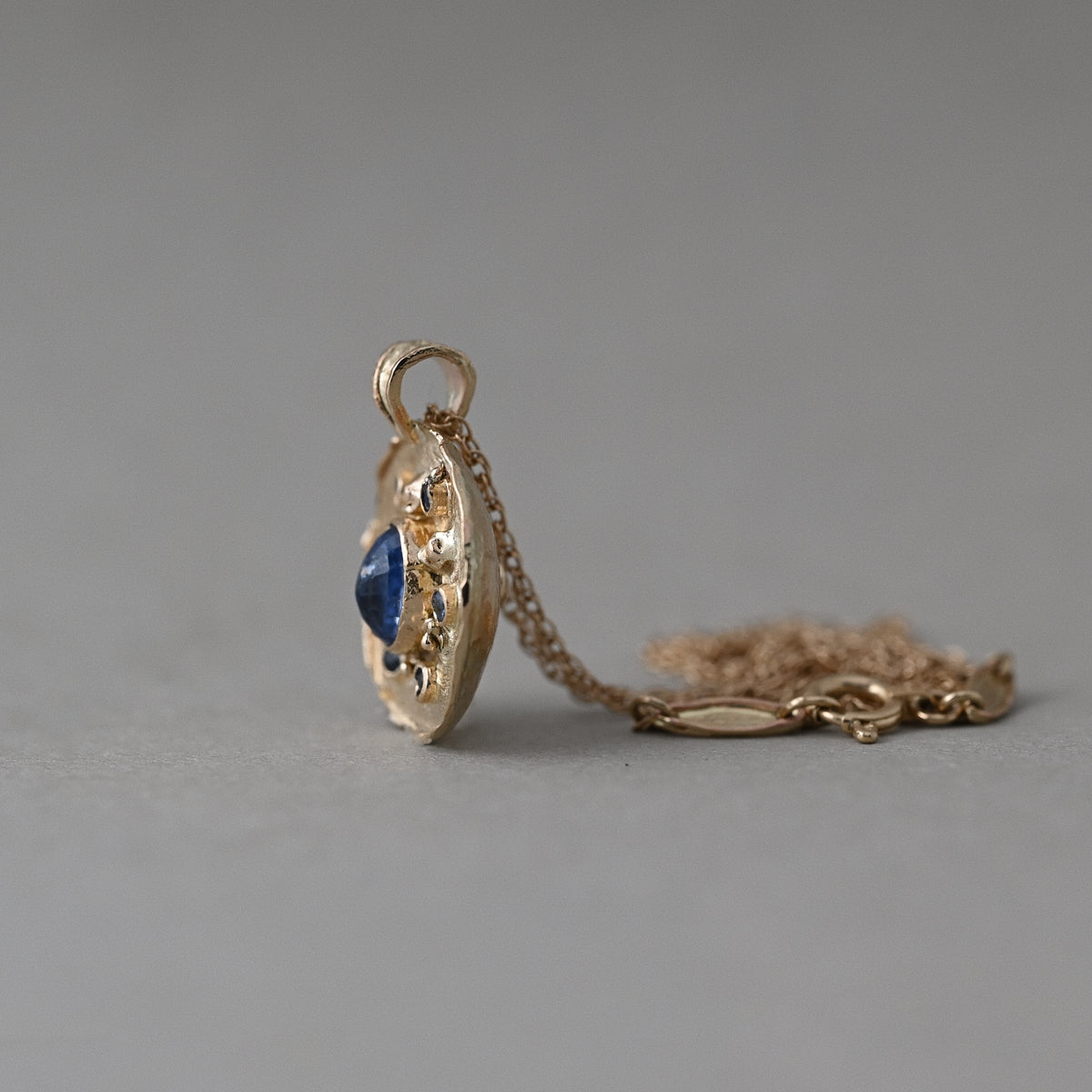 Side view of 14ct gold Florin Ceylon blue sapphire medallion pendant with gold chain