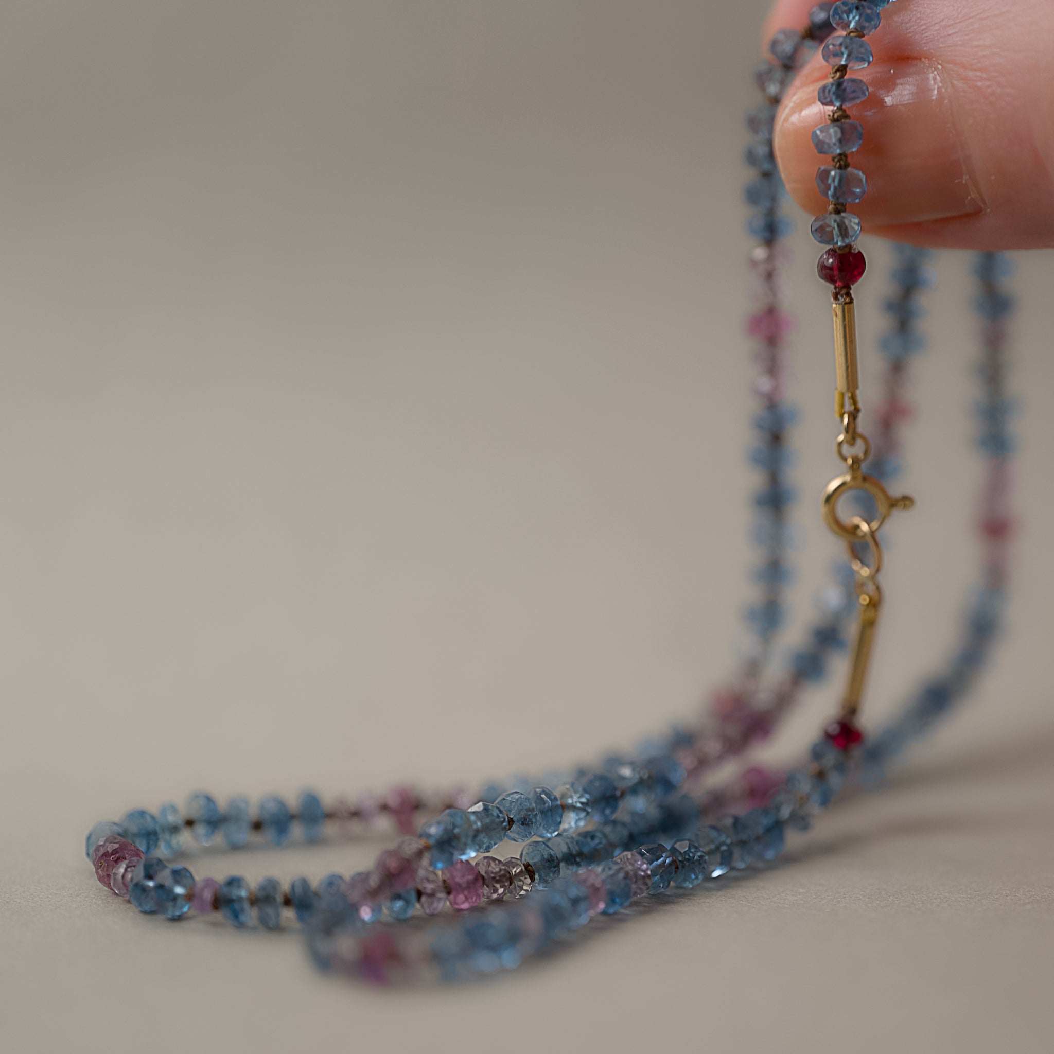 Lido aquamarine sapphire necklace  14ct gold clasp held in fingers 