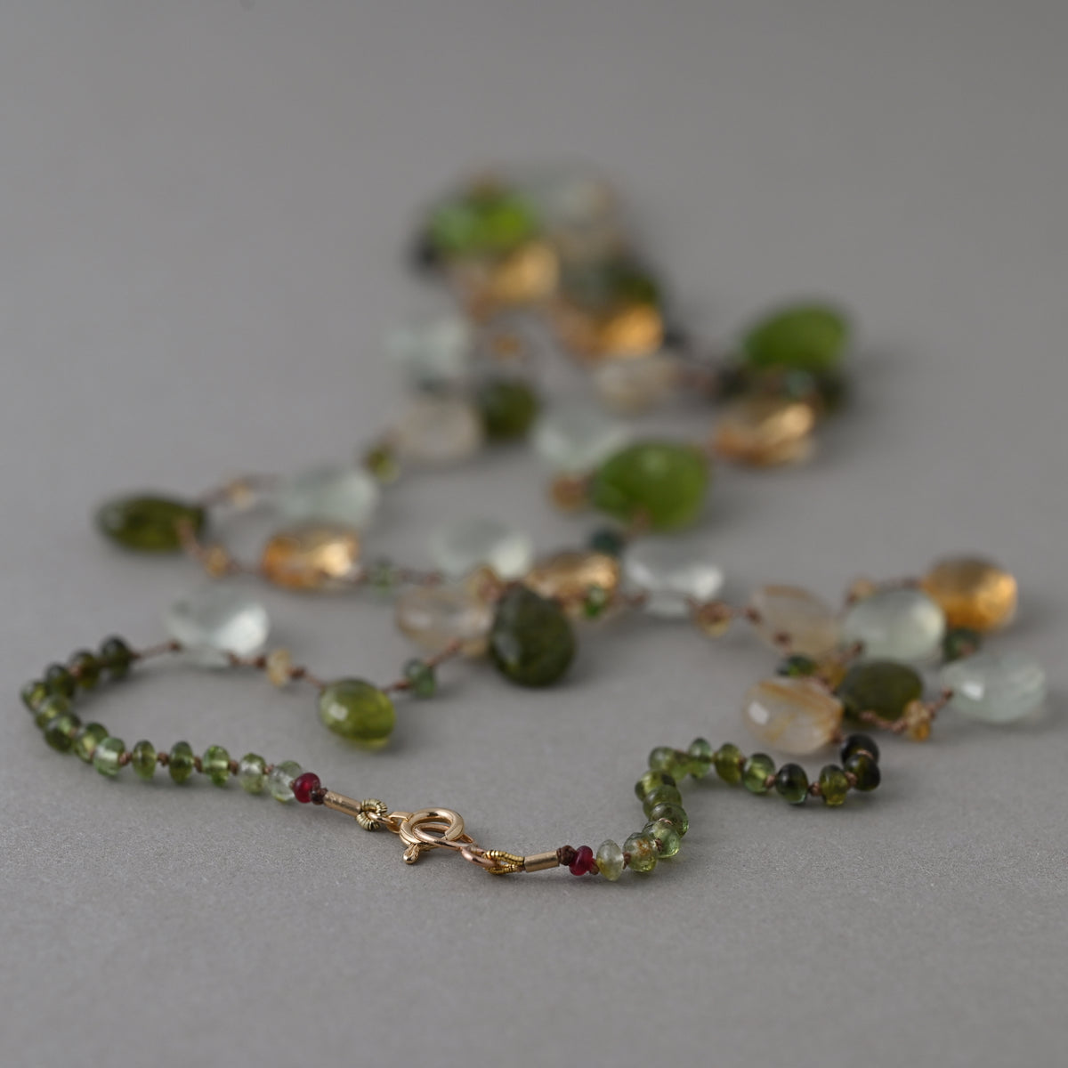 The clasp detail of  Lido silk necklace knotted with peridot, citrine, prehnite, quartz gemstones and finished with a 14ct gold clasp