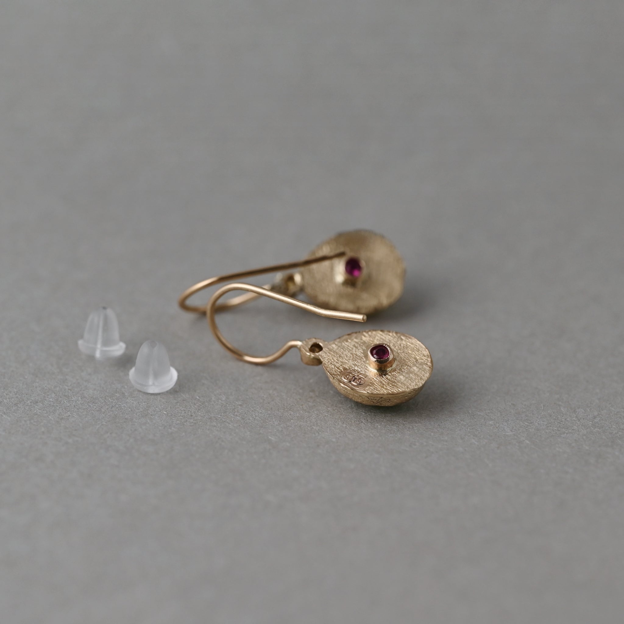 Back of handcrafted 14ct solid gold Pera peridot earrings with ruby-backed settings, 585 hallmark and shepherd hooks.