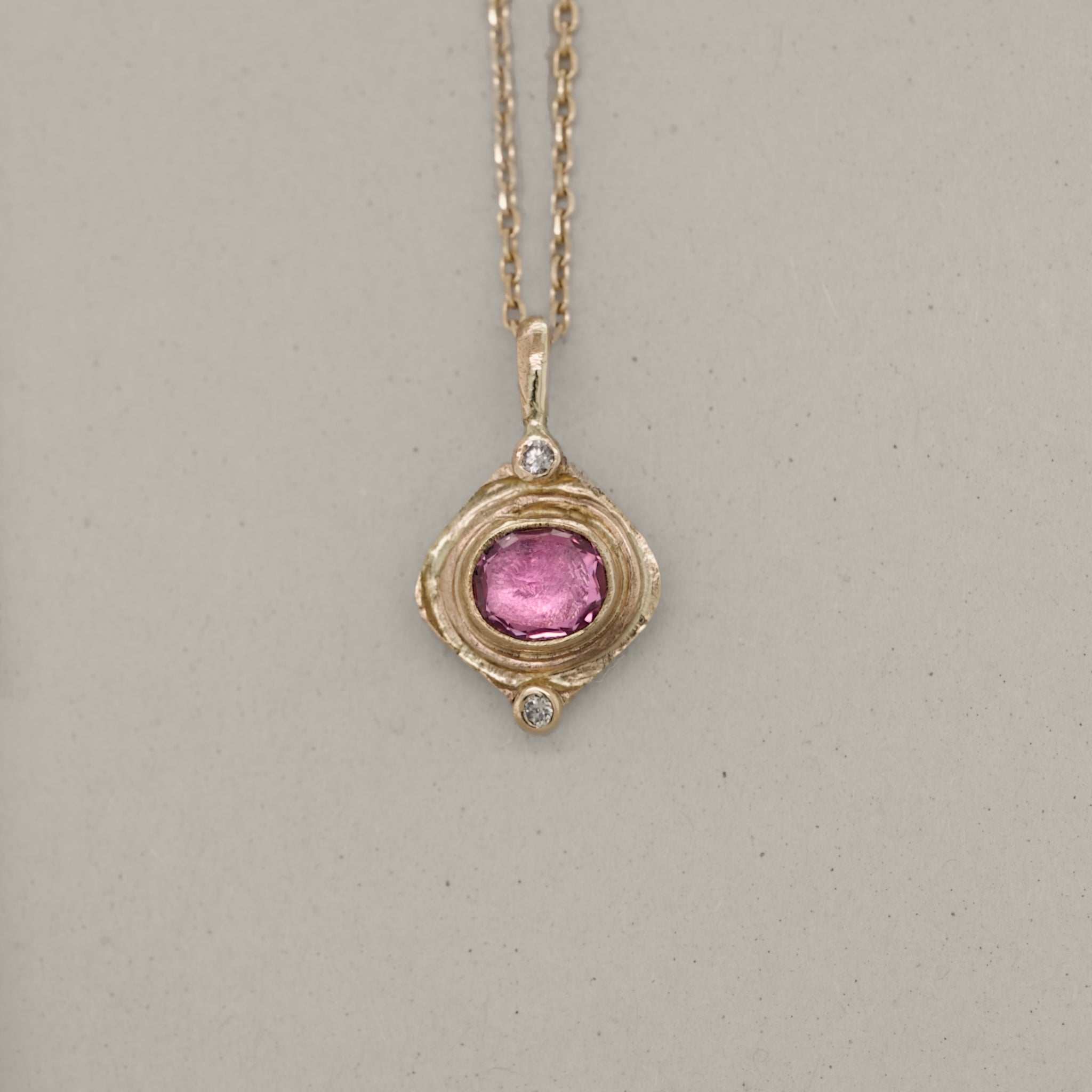 Pink sapphire and diamond pendant in 14ct gold, handmade by Vermilion Jewellery.
