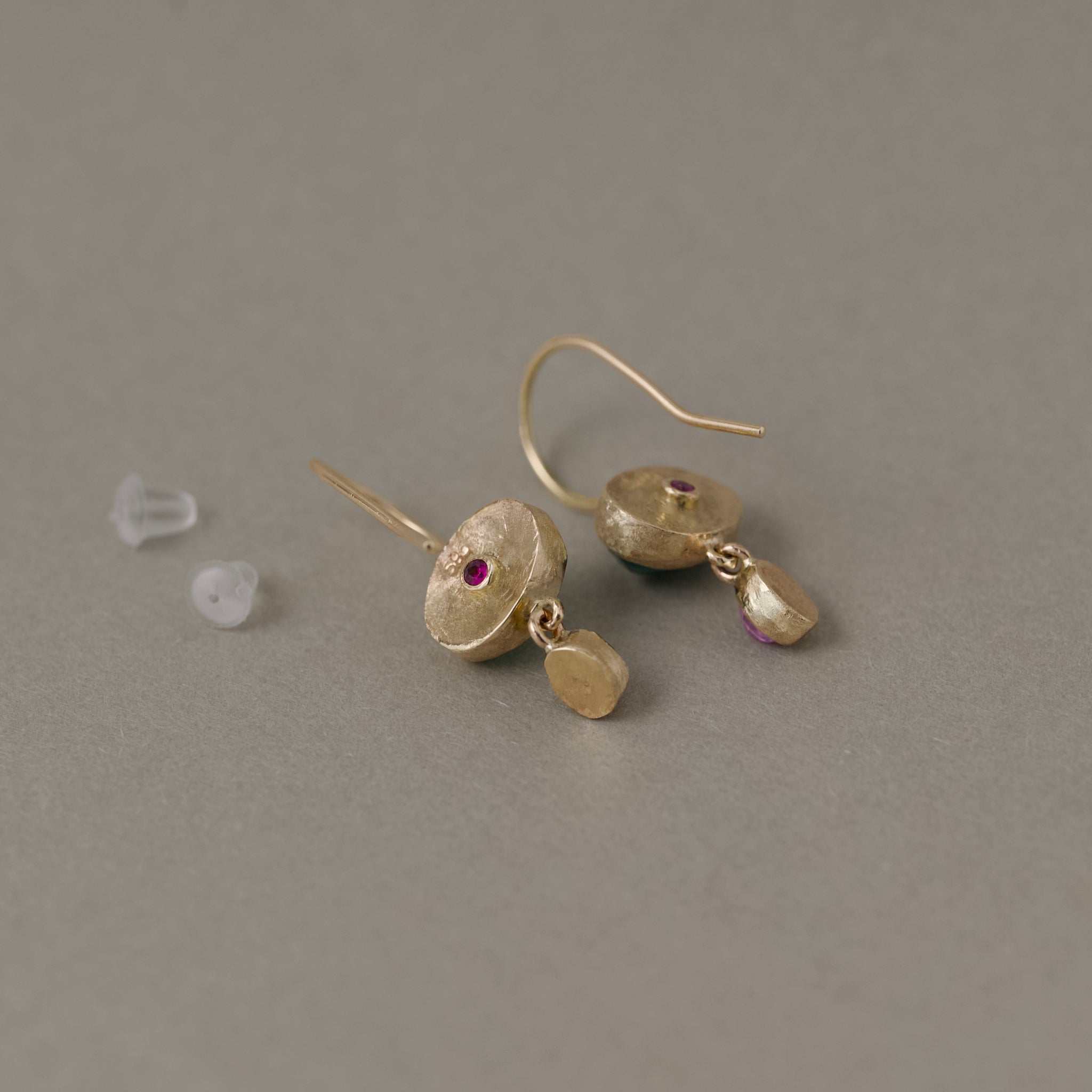Sera Zambian emerald earrings with blue-green emeralds and rose sapphires set in gold showing ruby backs
