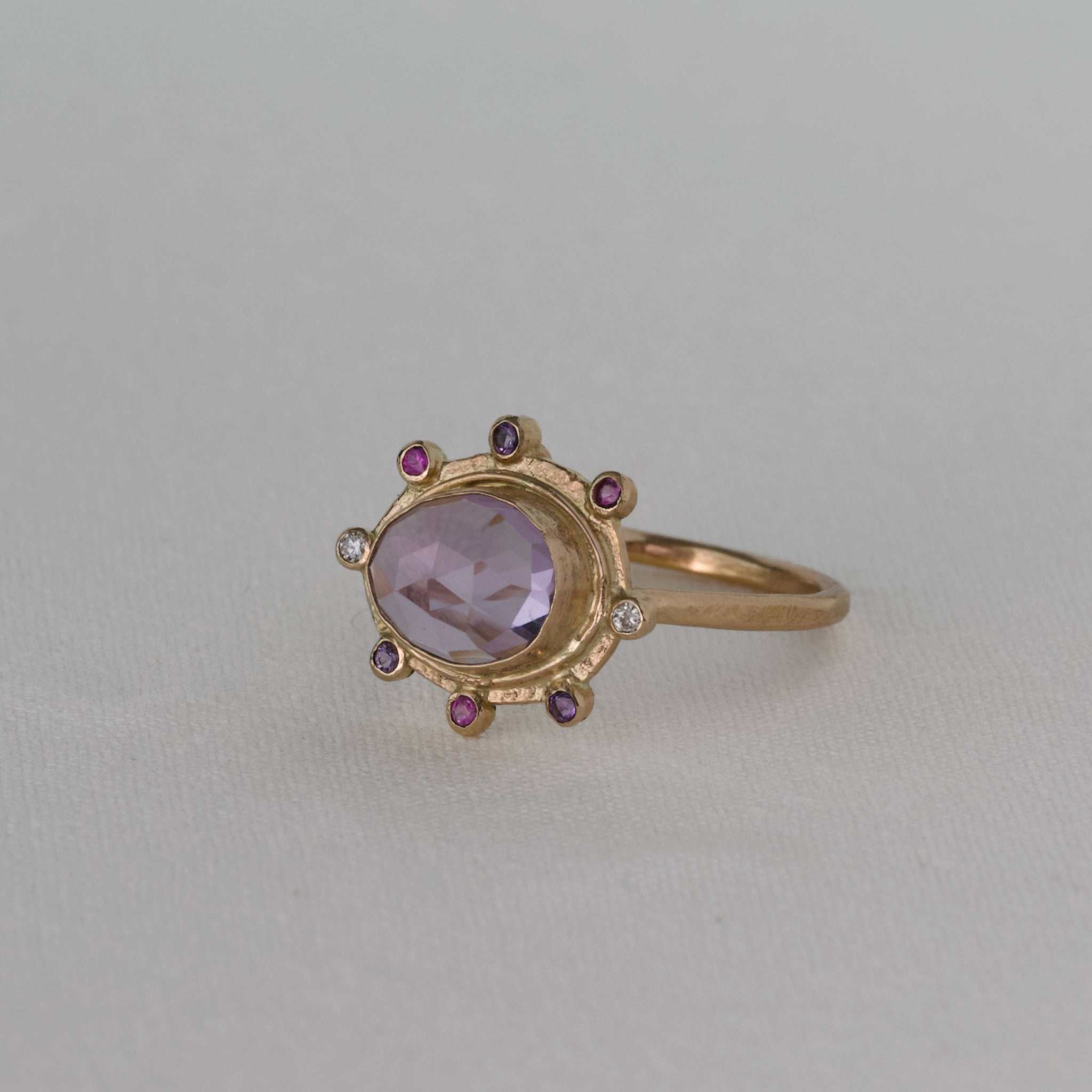 Amethyst ring with gold band, adorned with sapphires and diamonds.