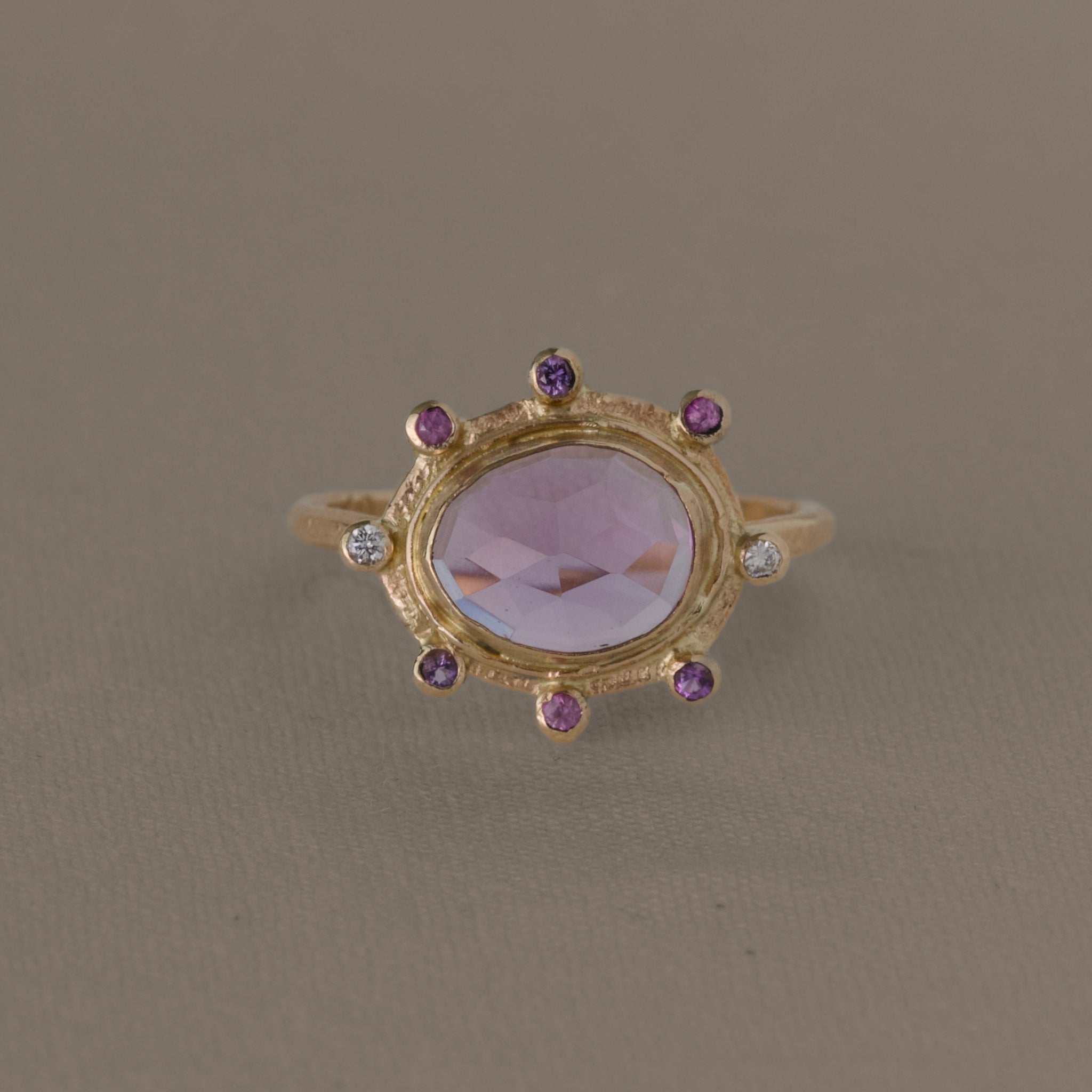 Gold amethyst ring adorned with sapphires and diamonds.