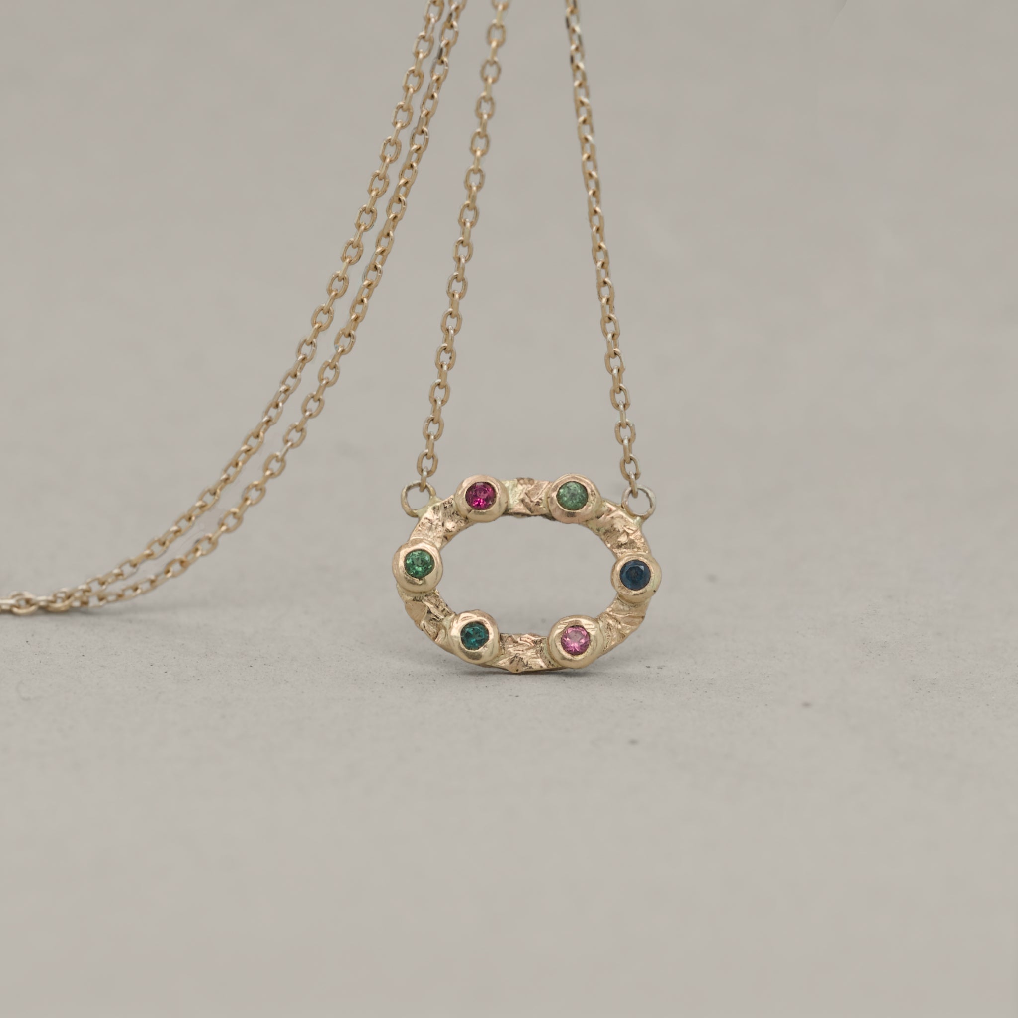 Tracery tourmaline pendant in gold lattice setting with multicolored tourmaline stones on delicate chain