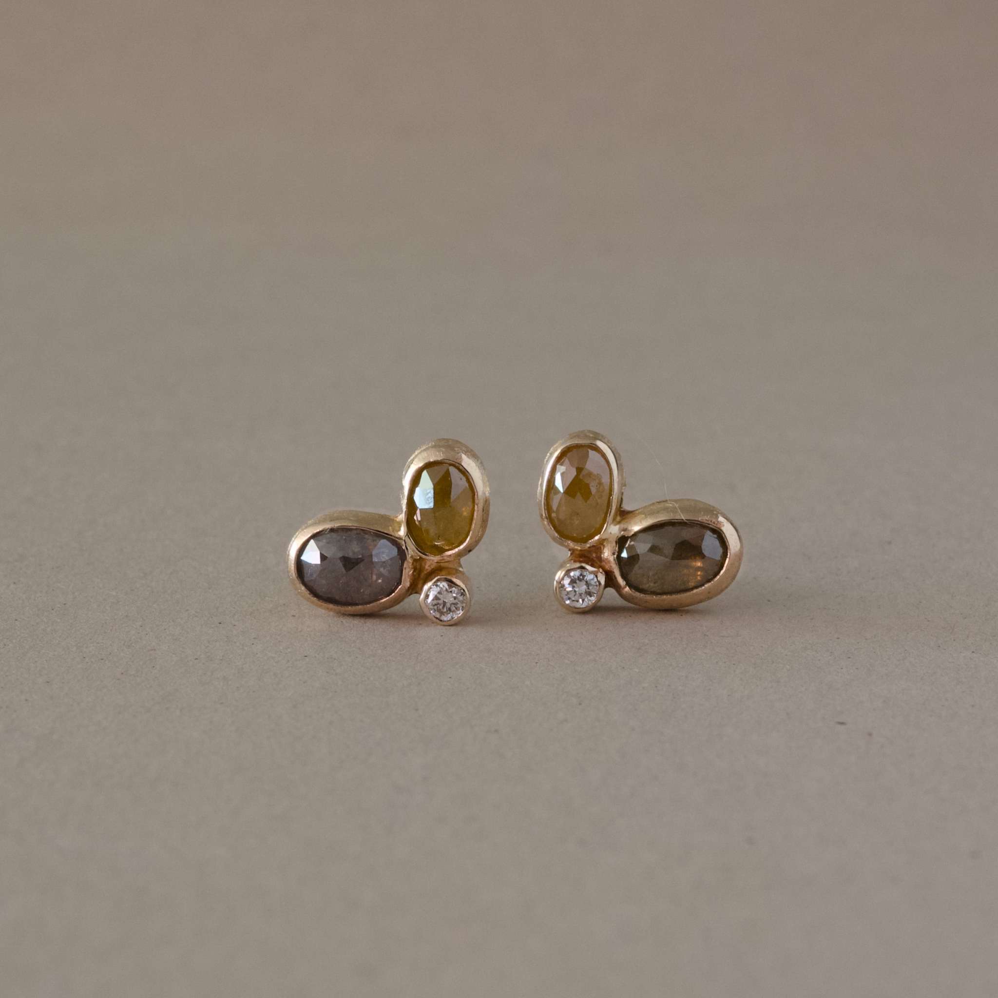  raw diamond stud earrings in gold with facetted raw diamonds and natural diamond accents.