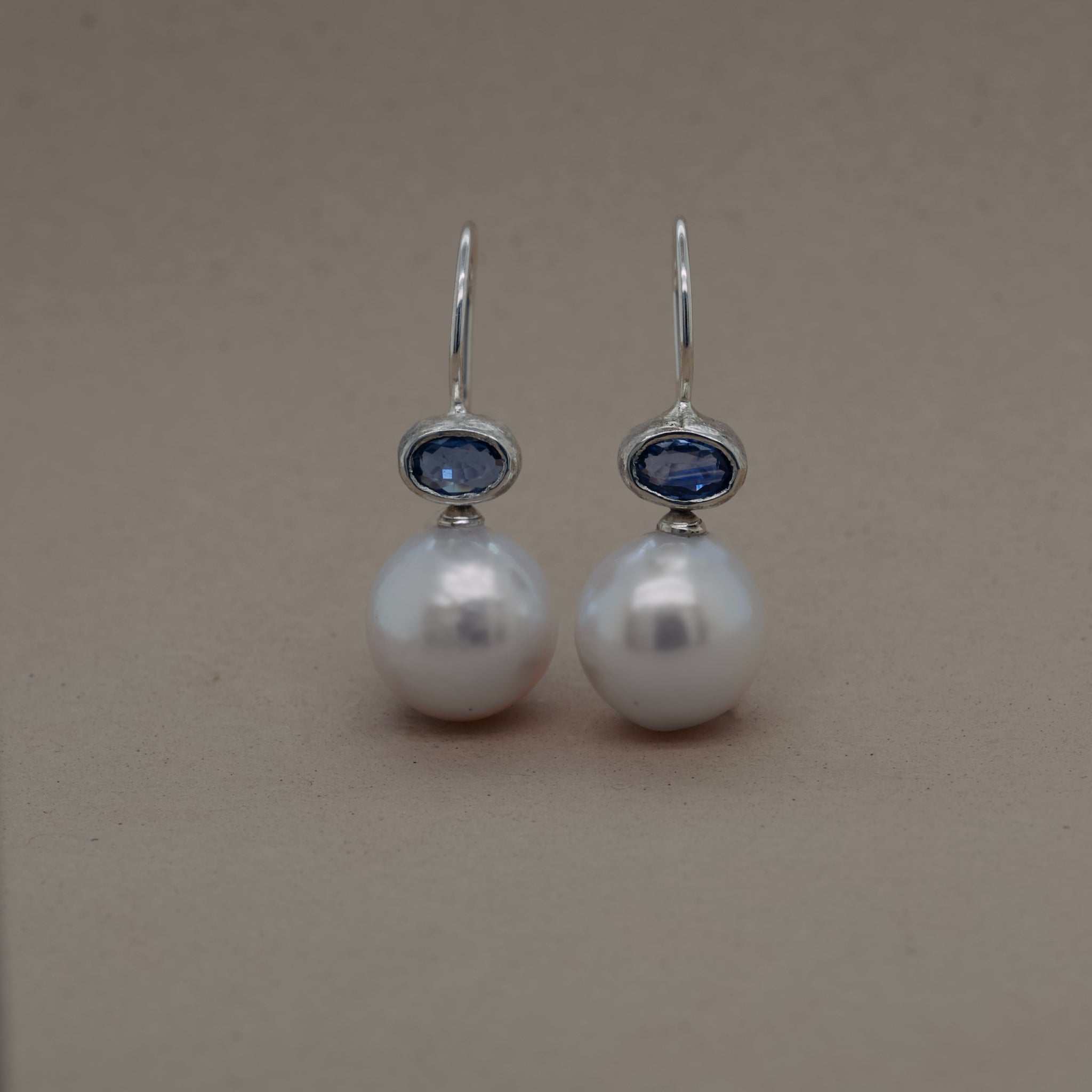 Silver blue sapphire pearl earrings with Ceylon sapphire on milk-hued pearls.