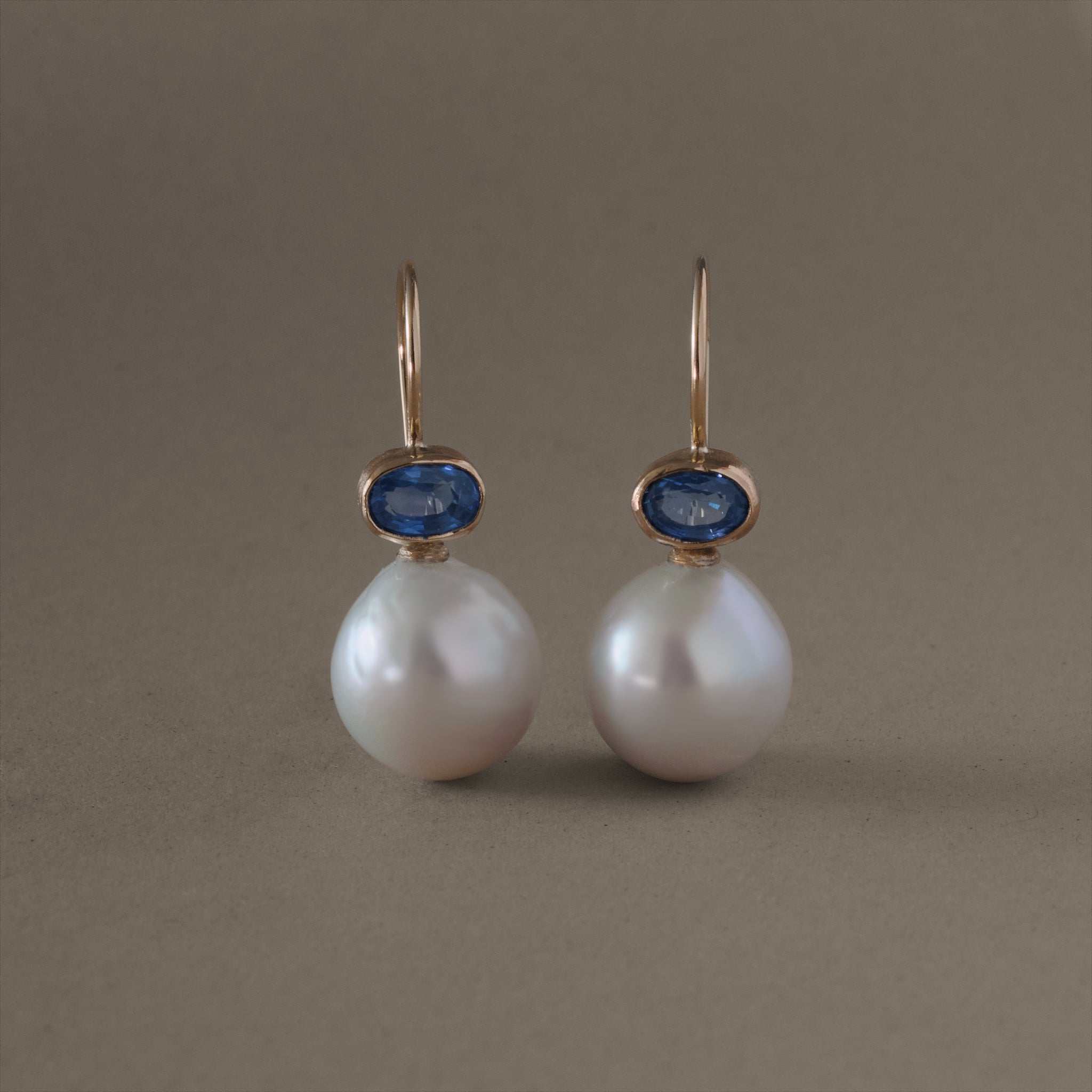 Blue sapphire pearl earrings with Ceylon sapphires and white pearls set in rich gold.