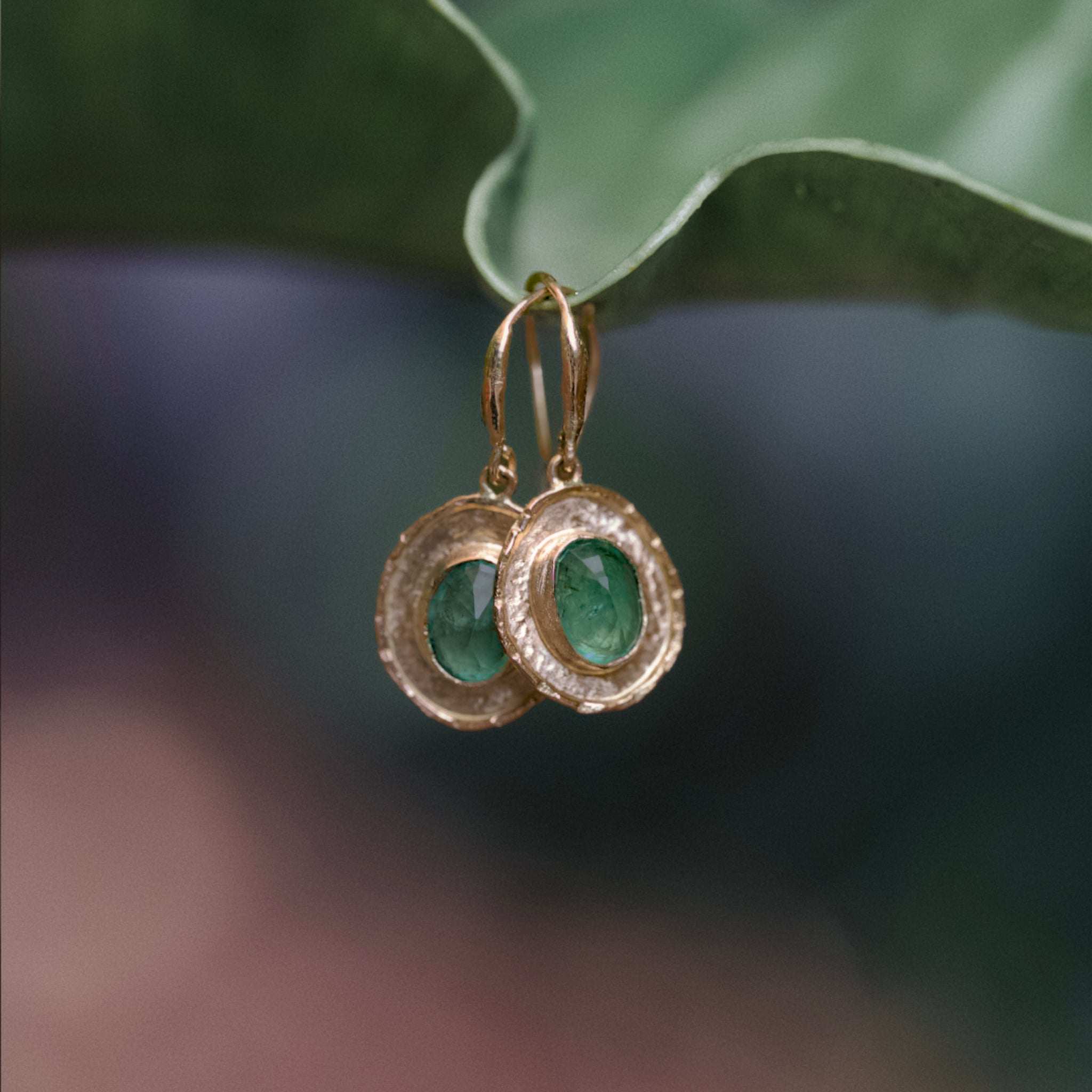 Gold coin earrings with hammered texture and vibrant blue-green emerald stones