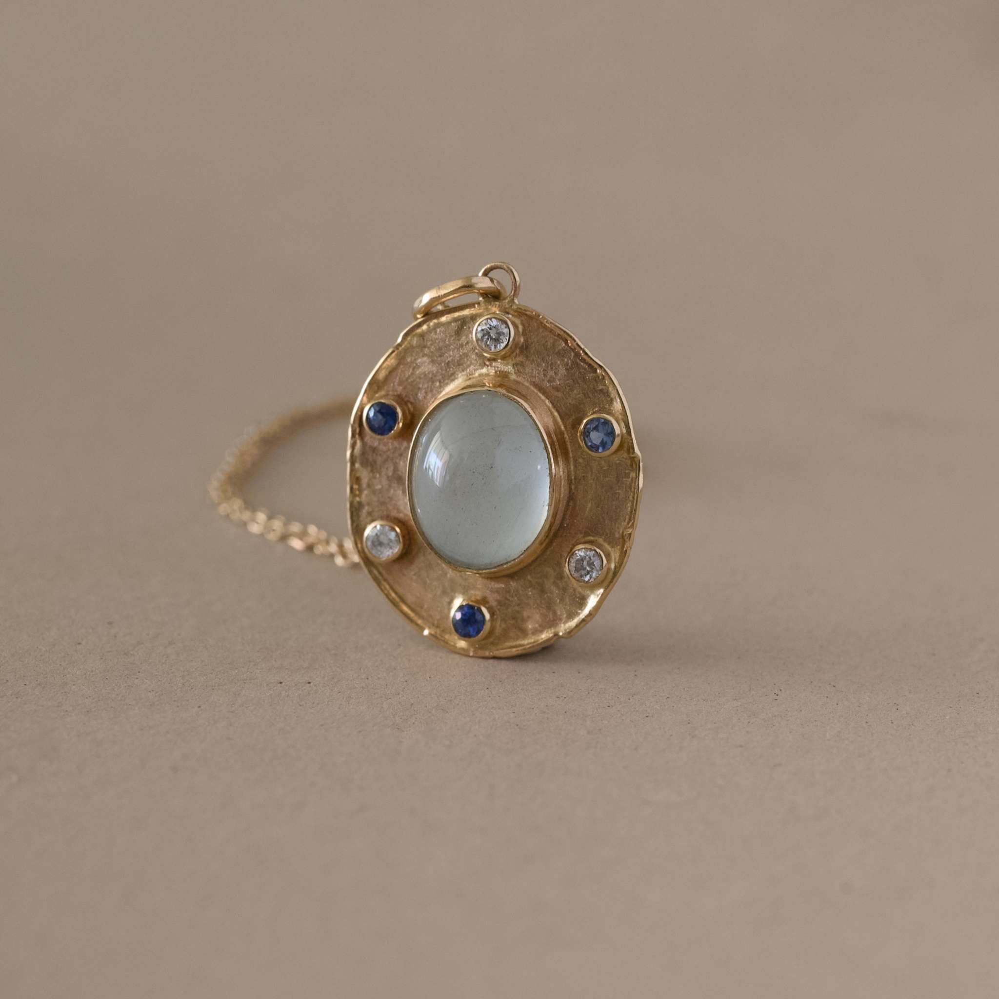 handcrafted florin aquamarine pendant in gold with aquamarine center and gem accents.