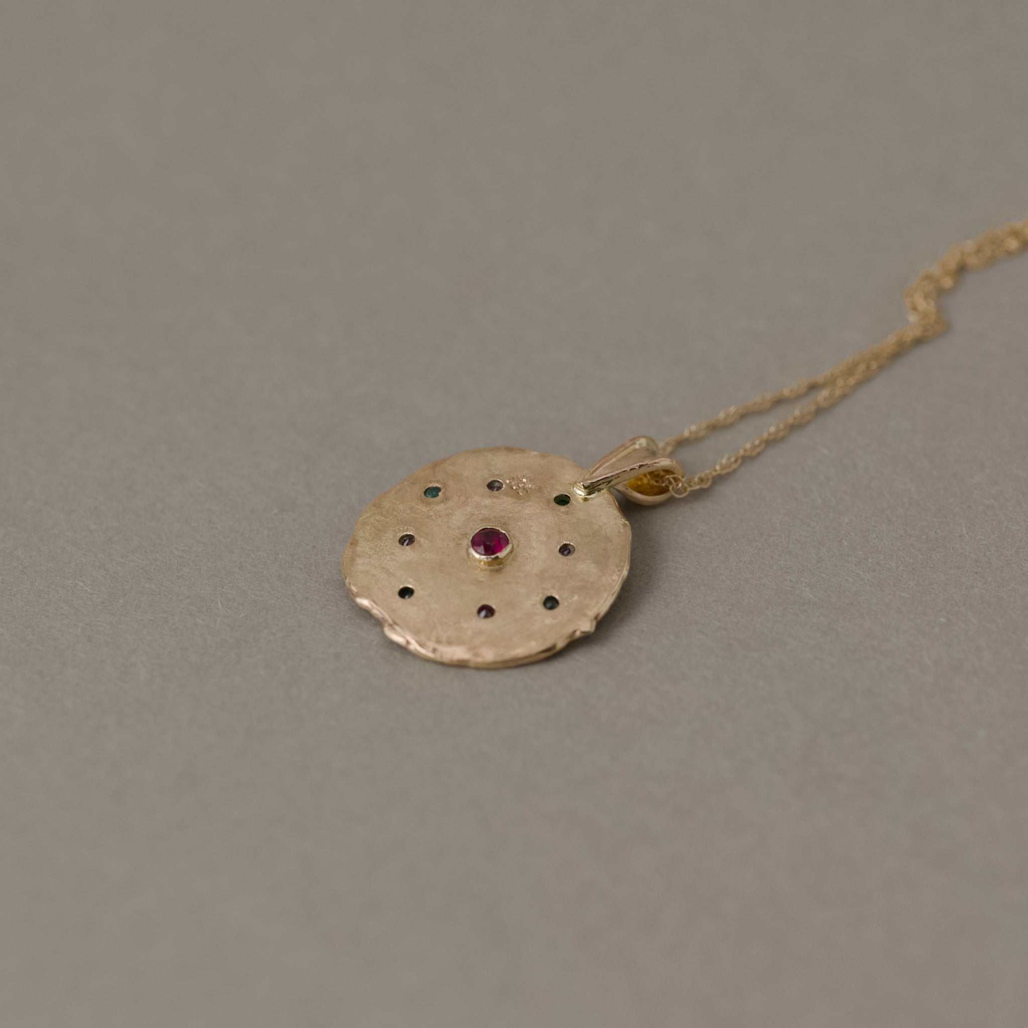 Florin pendant with emeralds, sapphires, set in 14ct gold showing back with ruby detail and double rope chain