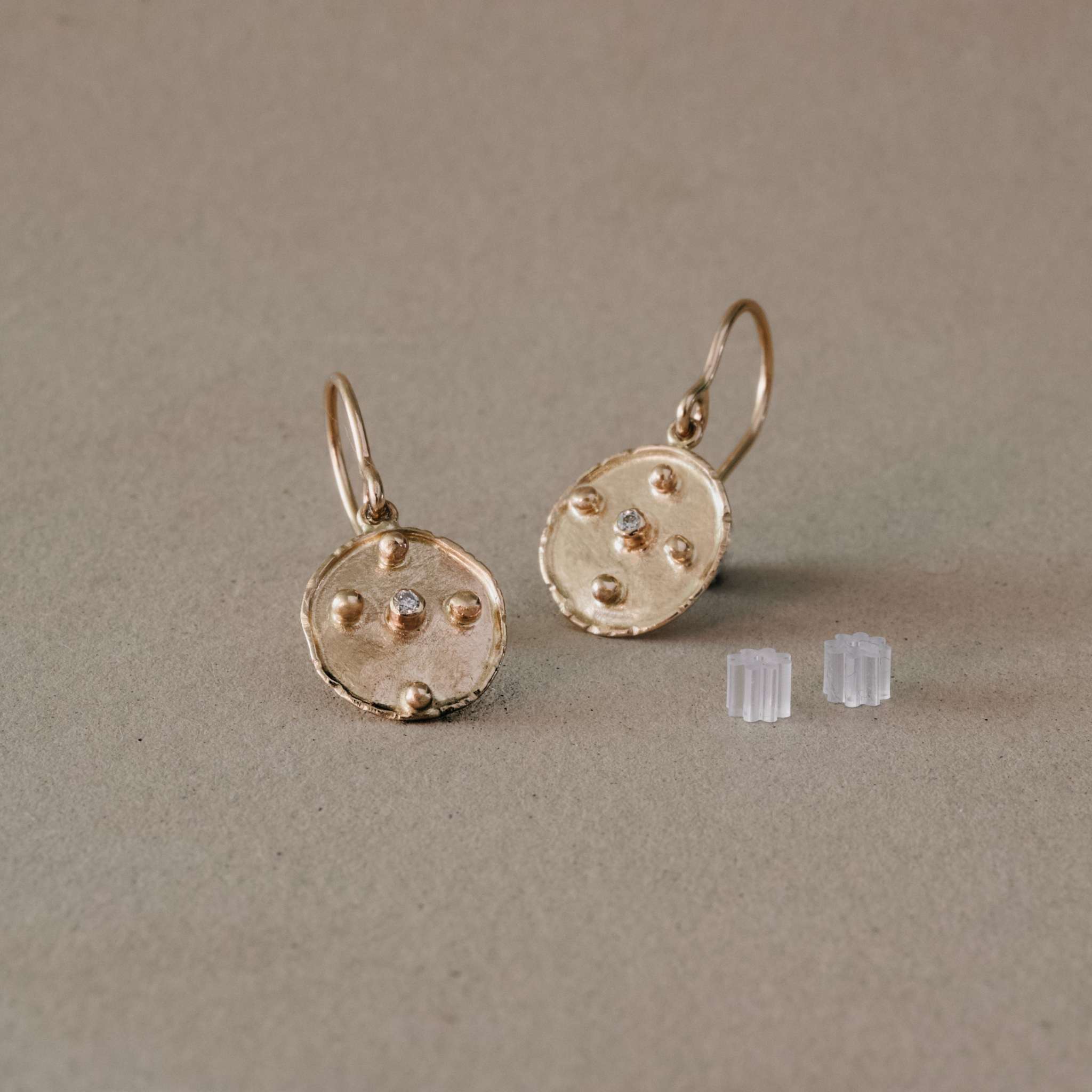 florin oro diamond earrings with gold ball accents and brilliant cut diamond.