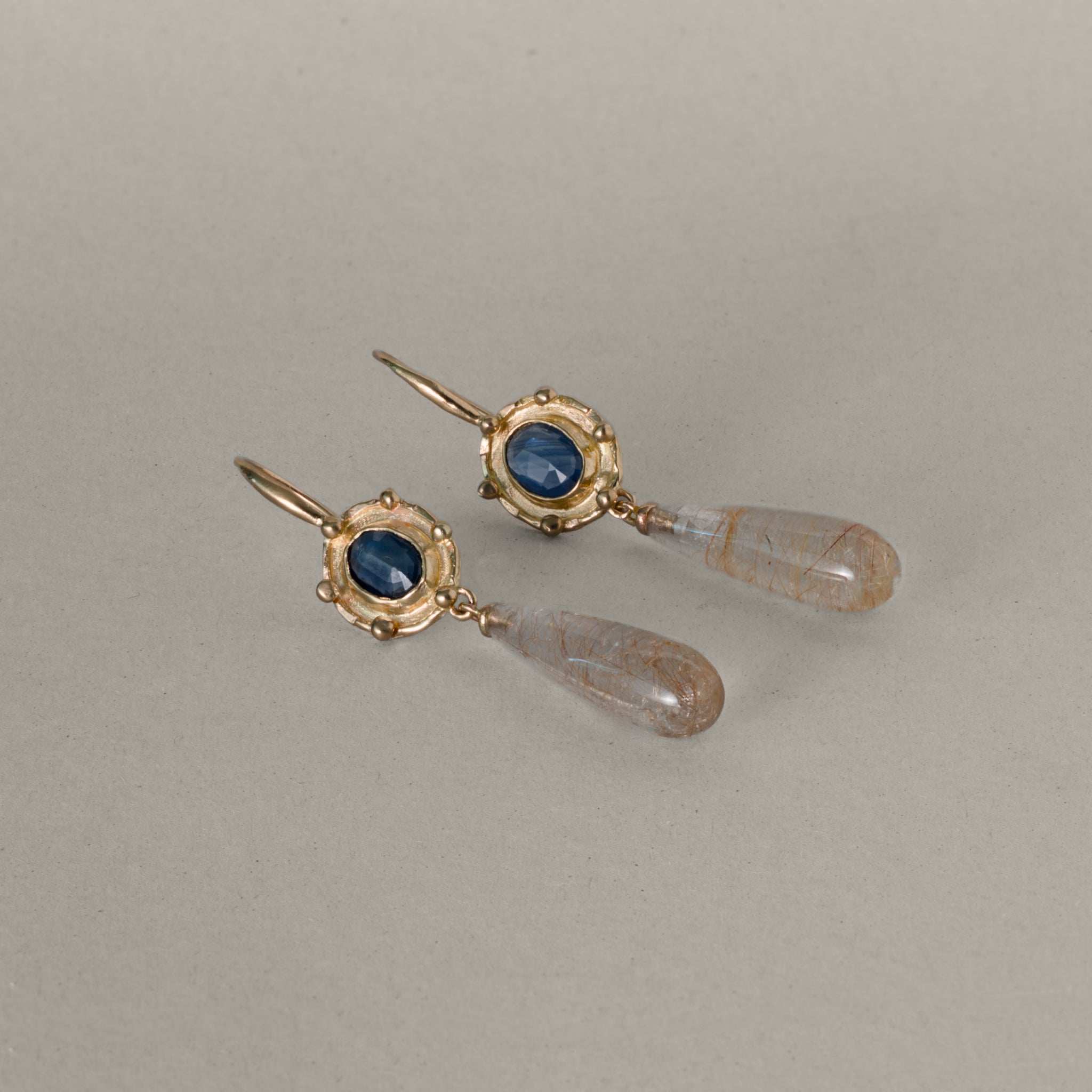 Florin Sapphire Quartz drop earrings with gold setting, deep blue sapphires, and elongated quartz pendants