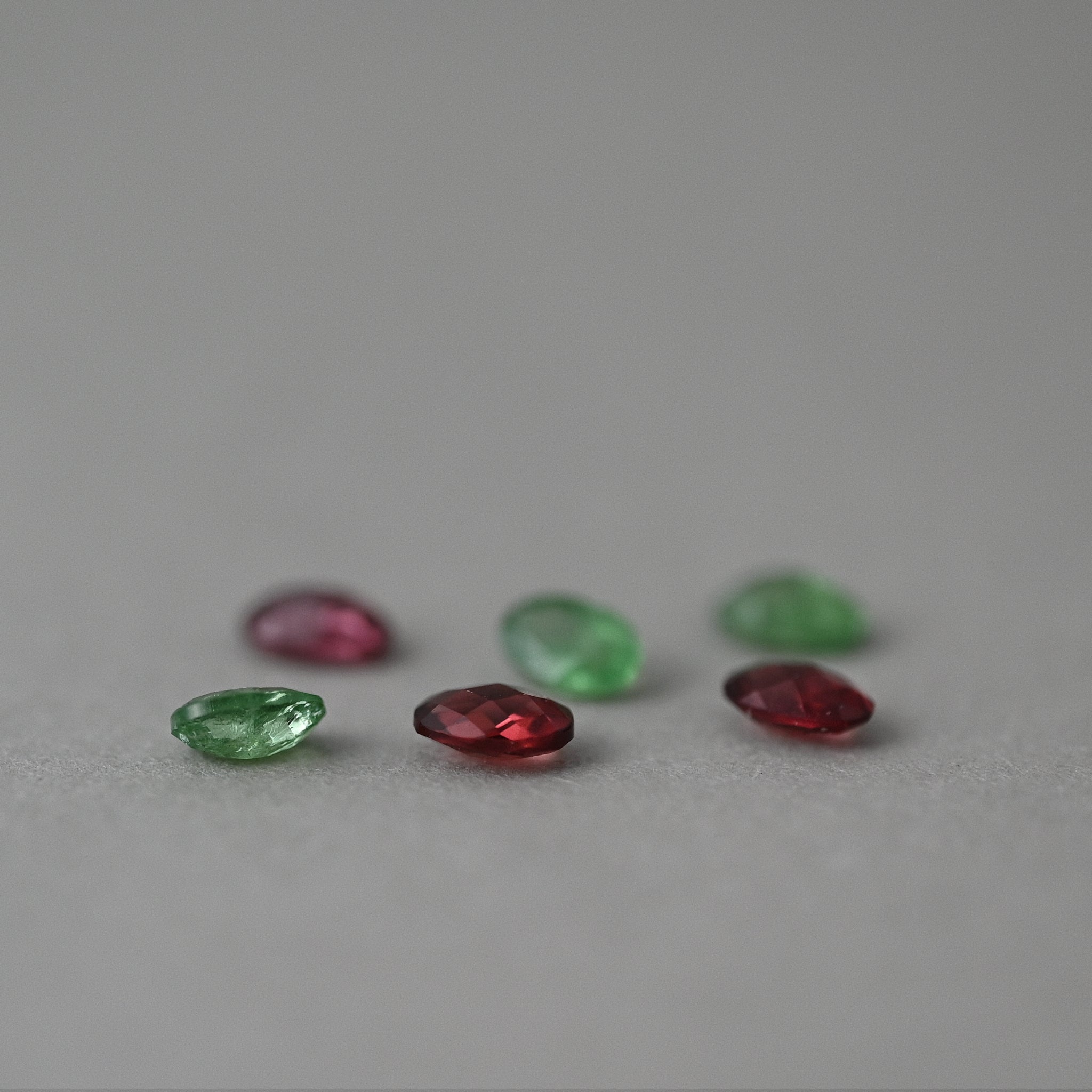 loose garnet gemstones on grey paper