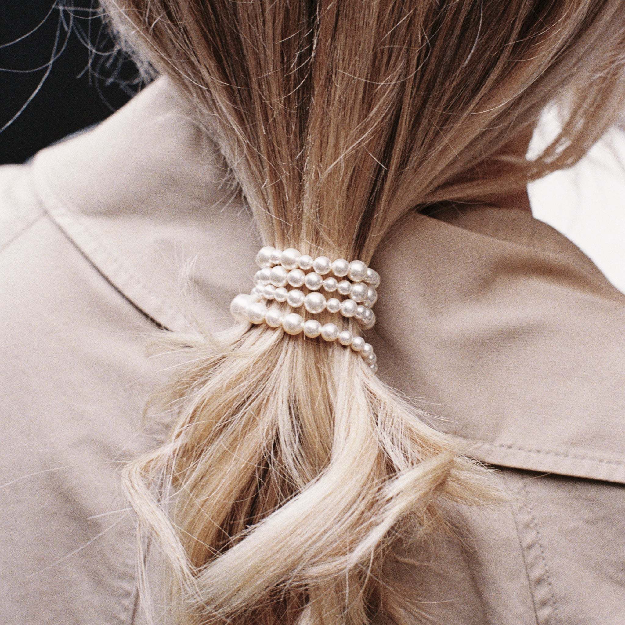 Ondina Freshwater Pearl Necklace worn as hair accessory on blonde hair with beige coat background