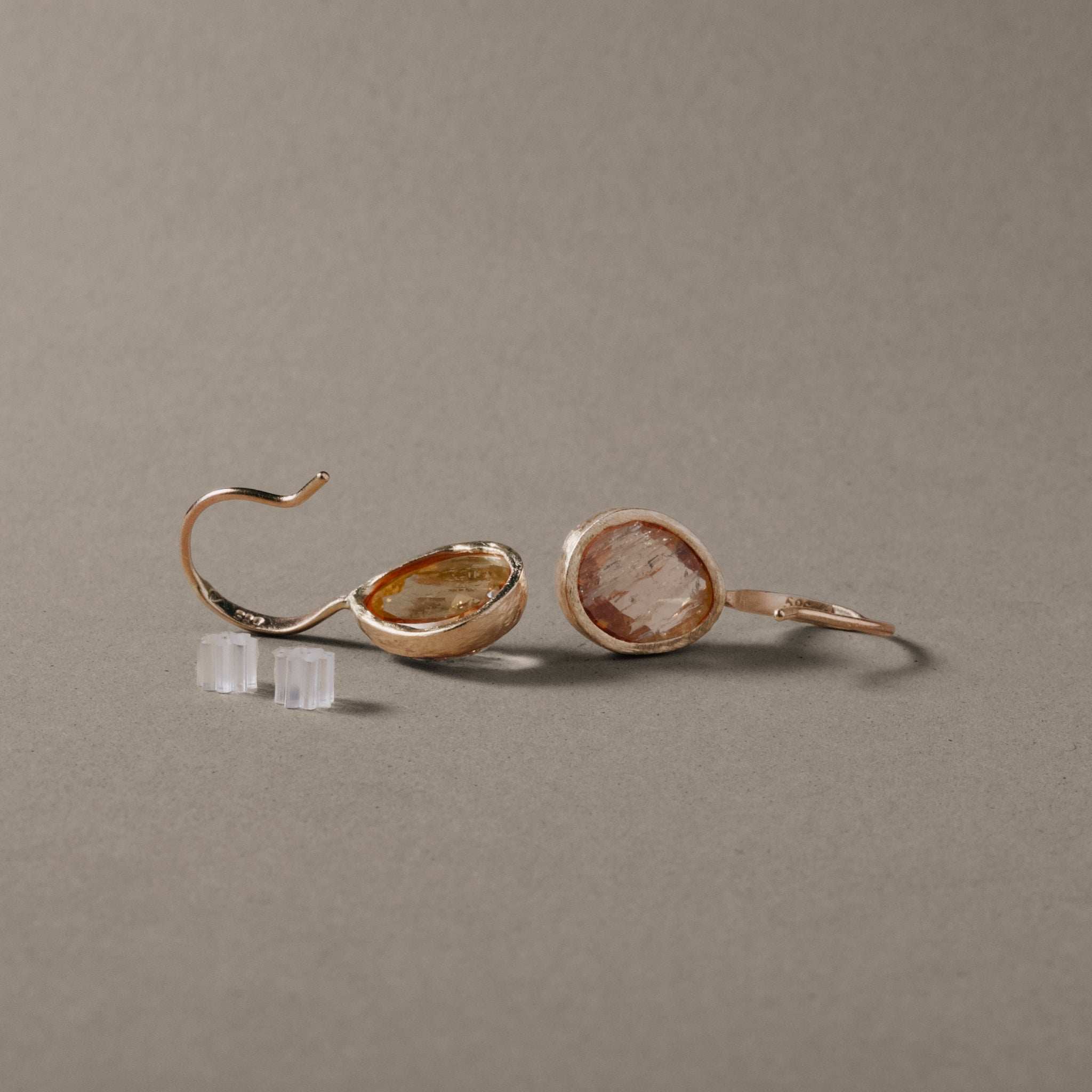 Imperial topaz earrings in teardrop shape set in gold with warm gold and peach hues.