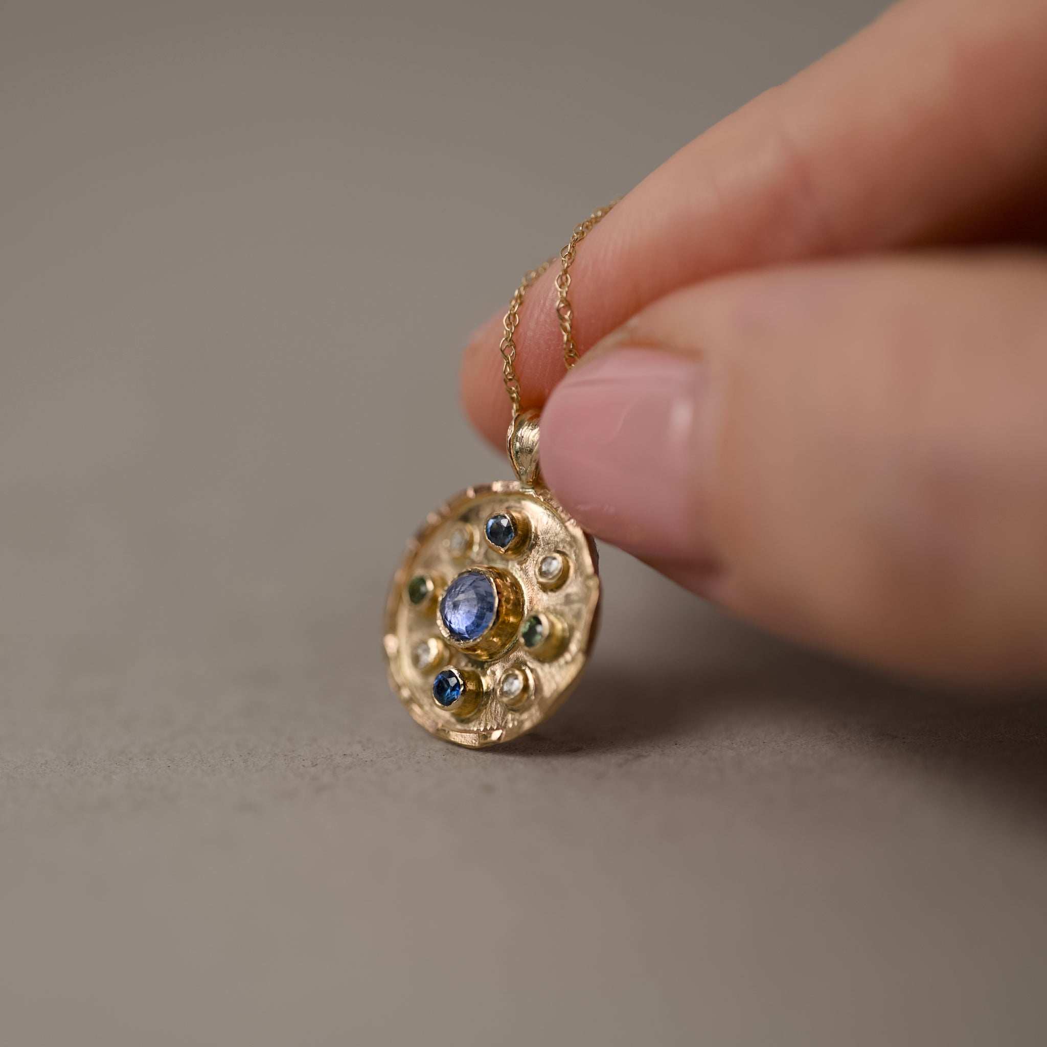 florin blue sapphire rose cut diamond pendant held in hand