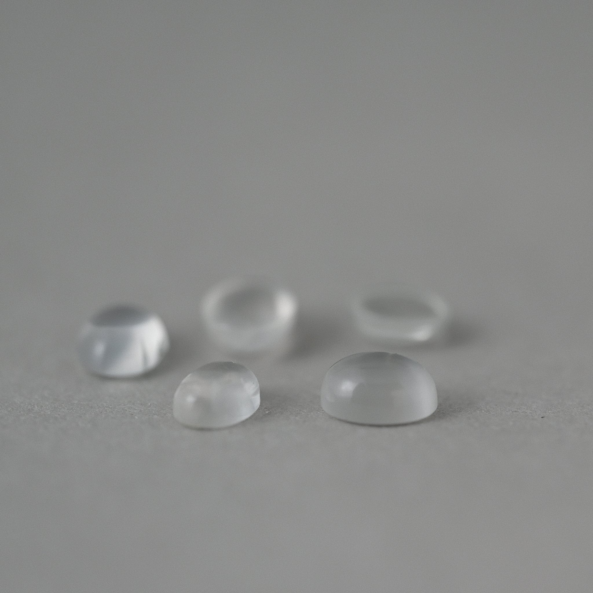 loose moonstone gemstones on grey paper