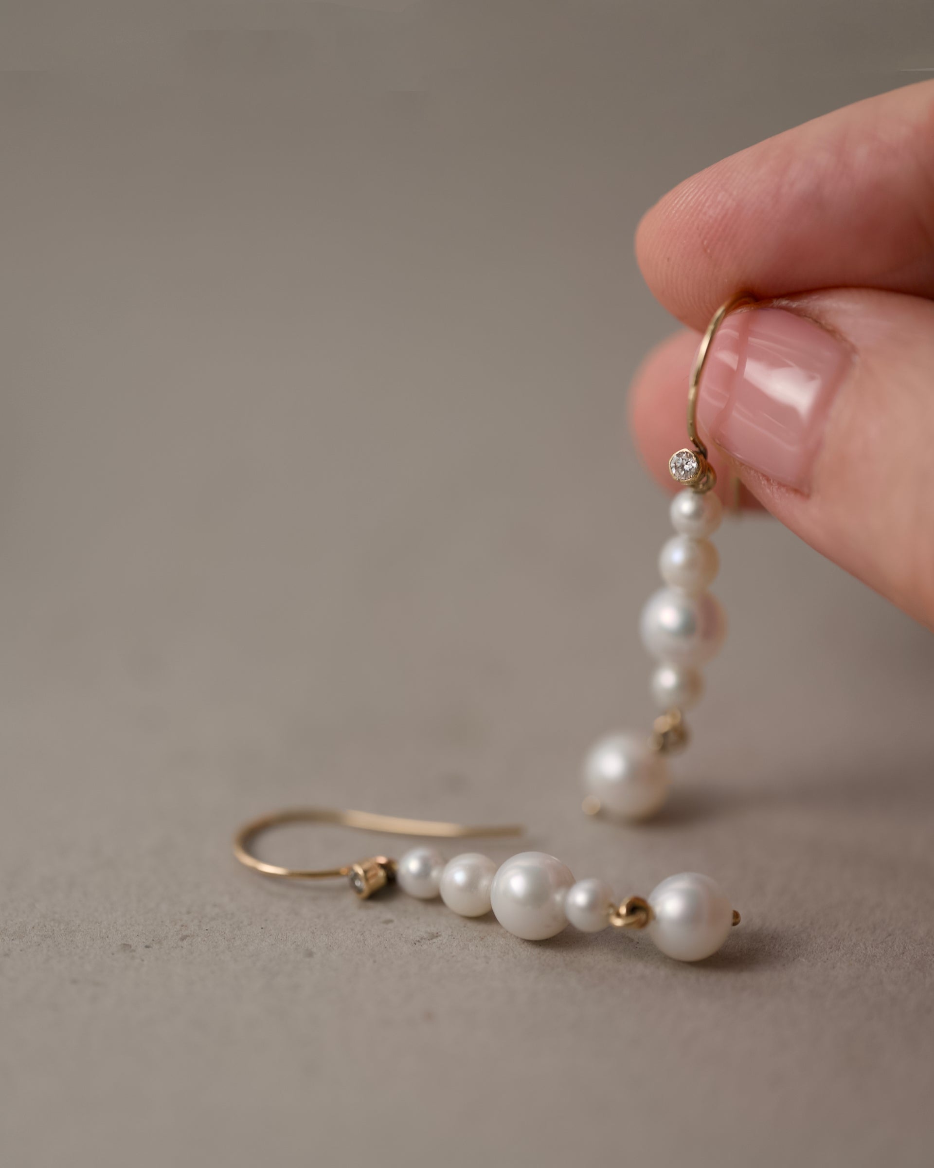 reshwater pearl earrings in solid gold shown on hand